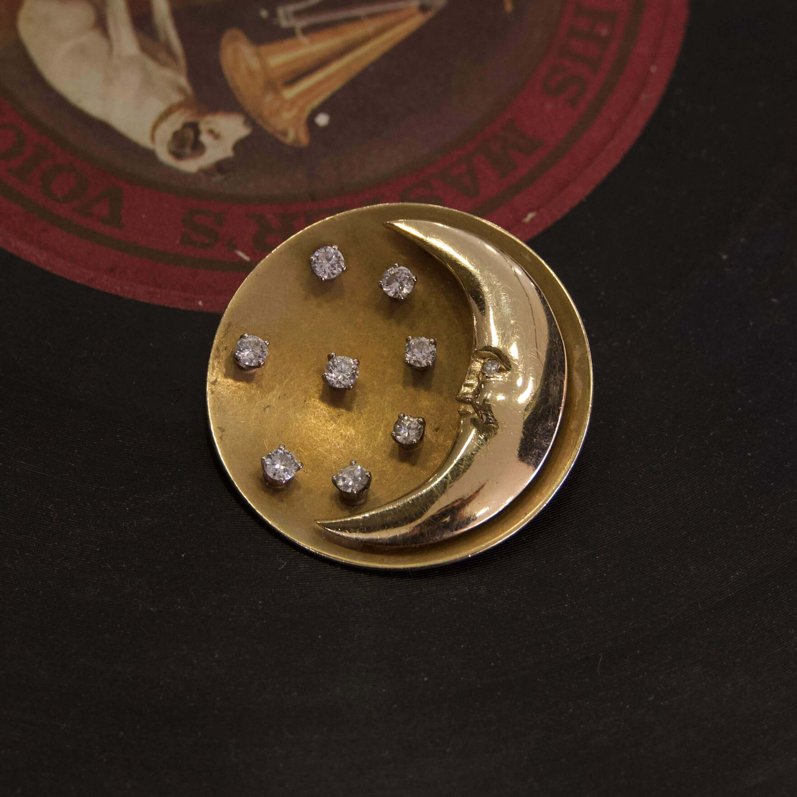 Gold moon brooch with small gems.