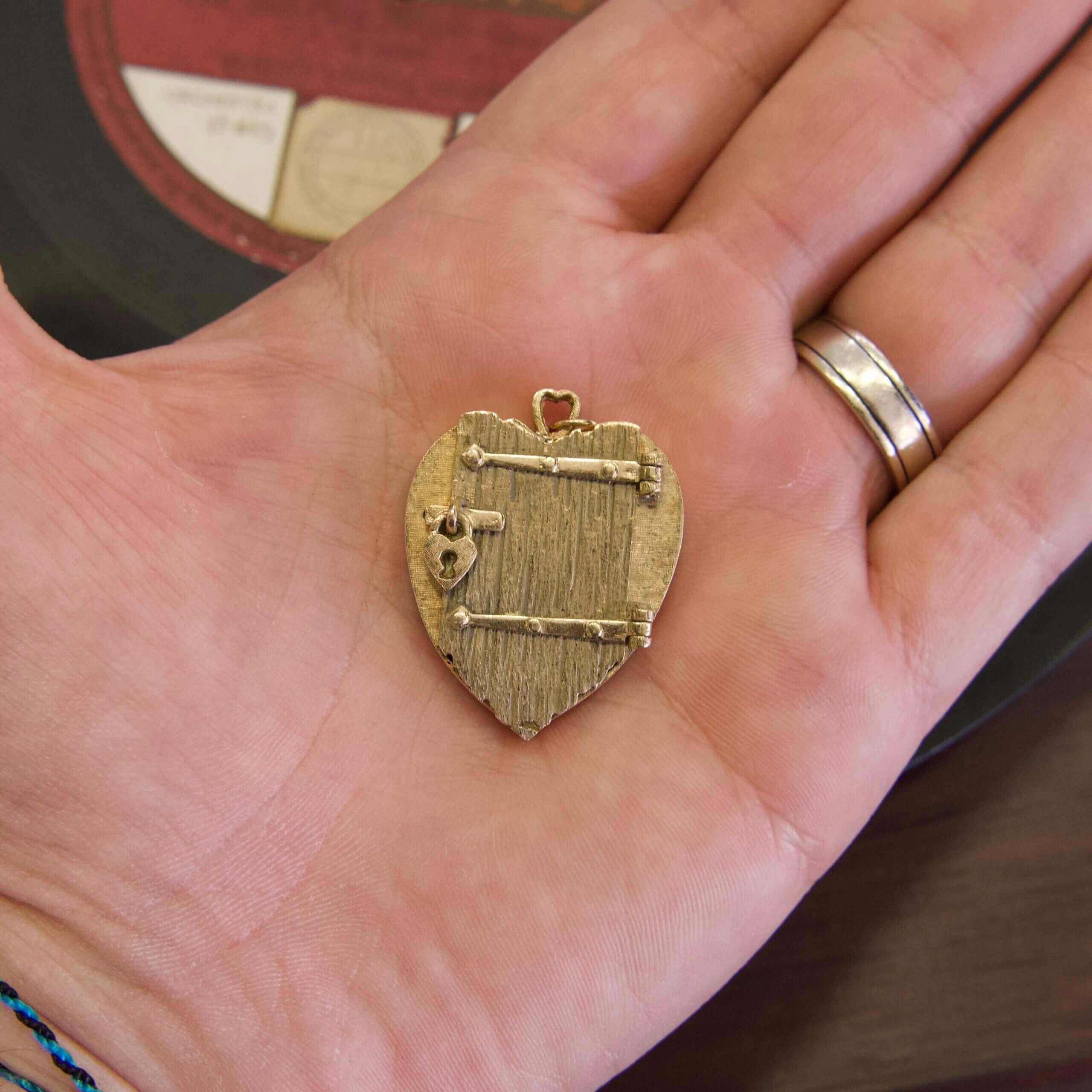 Heart-shaped locket in a person's hand.
