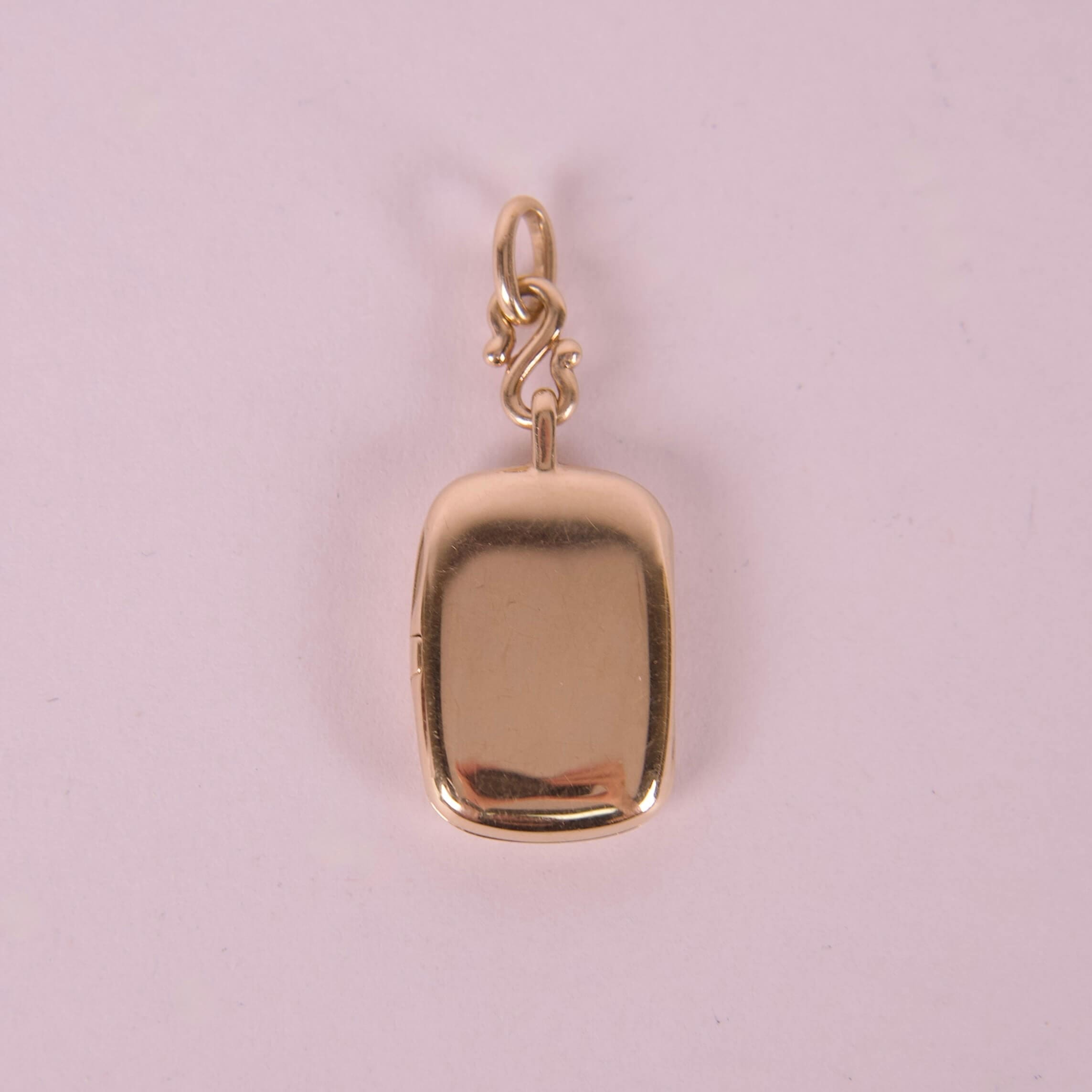 Gold rectangular locket with loop attachment.