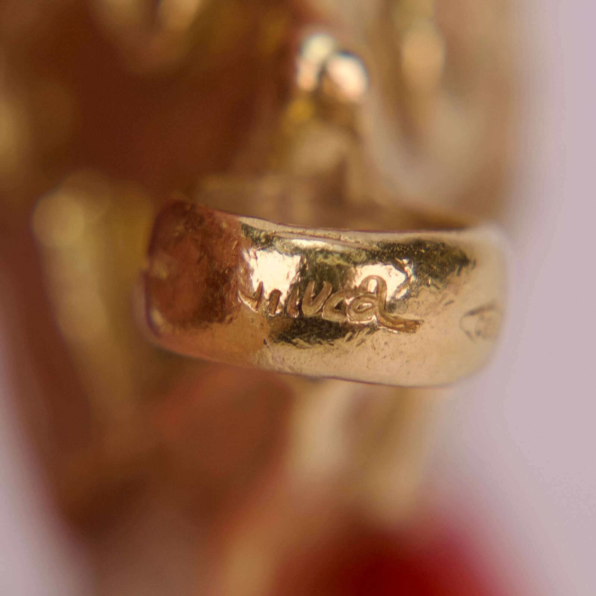 Gold ring with engraved signature close-up.