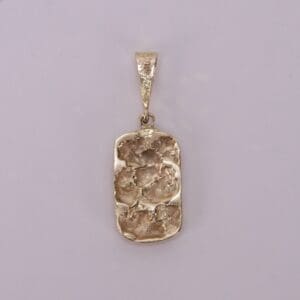 Gold textured pendant on plain background.