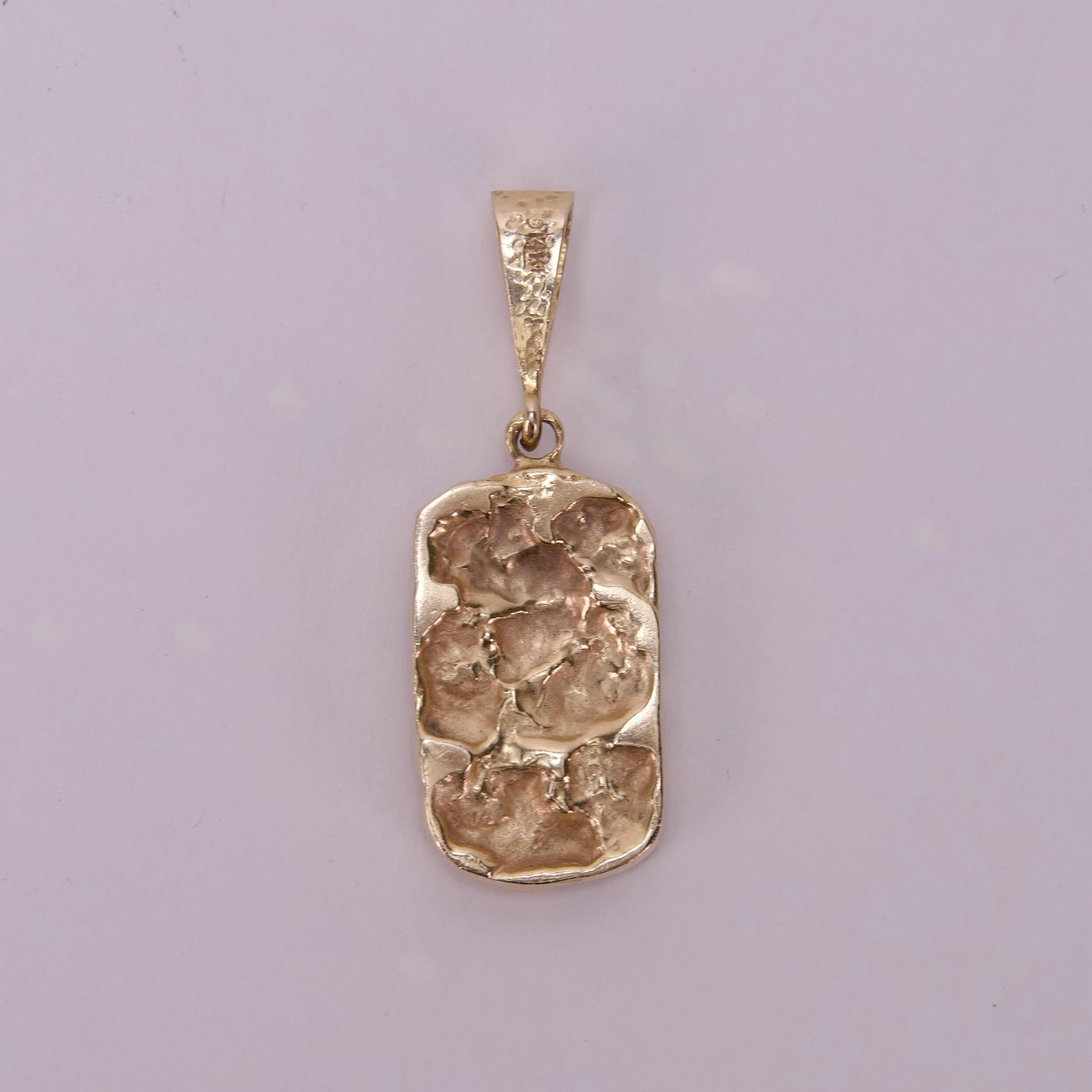 Gold textured pendant on plain background.