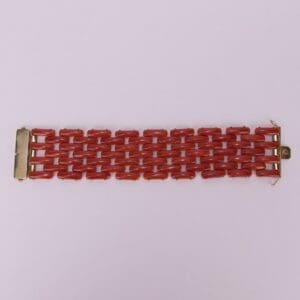 Red linked bracelet on pink background.