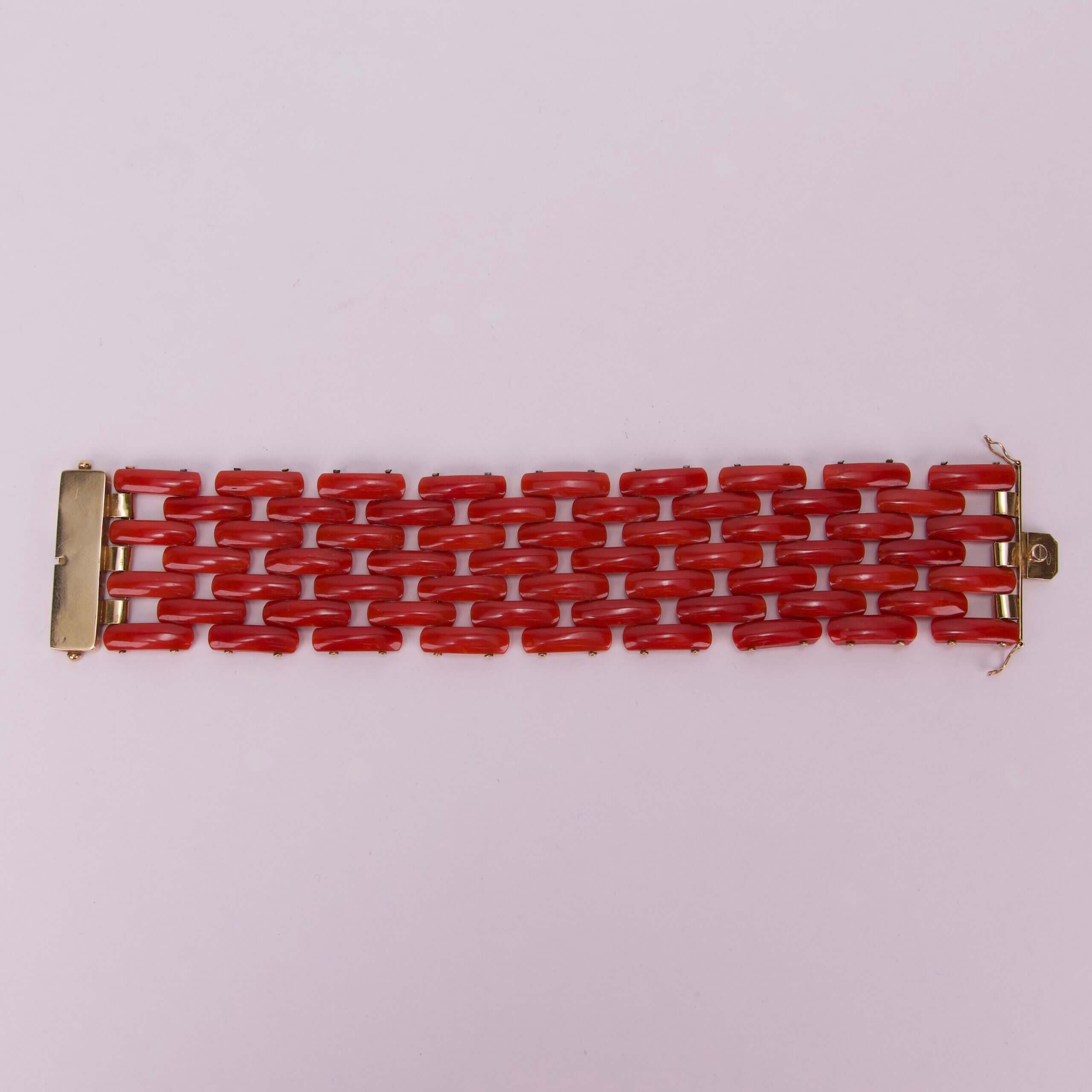 Red linked bracelet on pink background.
