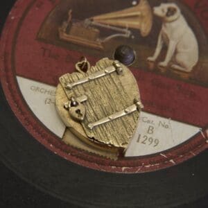 Gold pendant on vintage record label background.