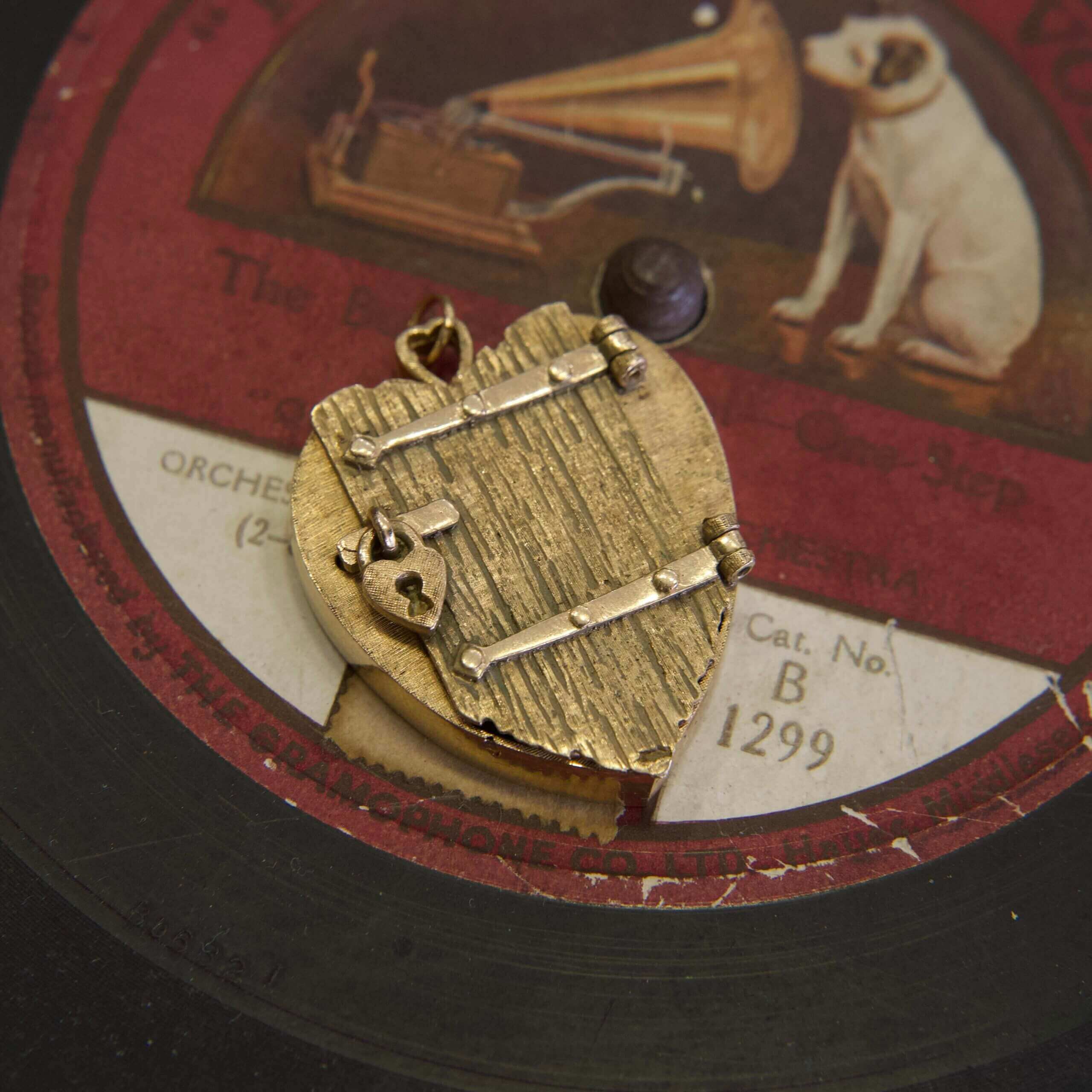 Gold pendant on vintage record label background.