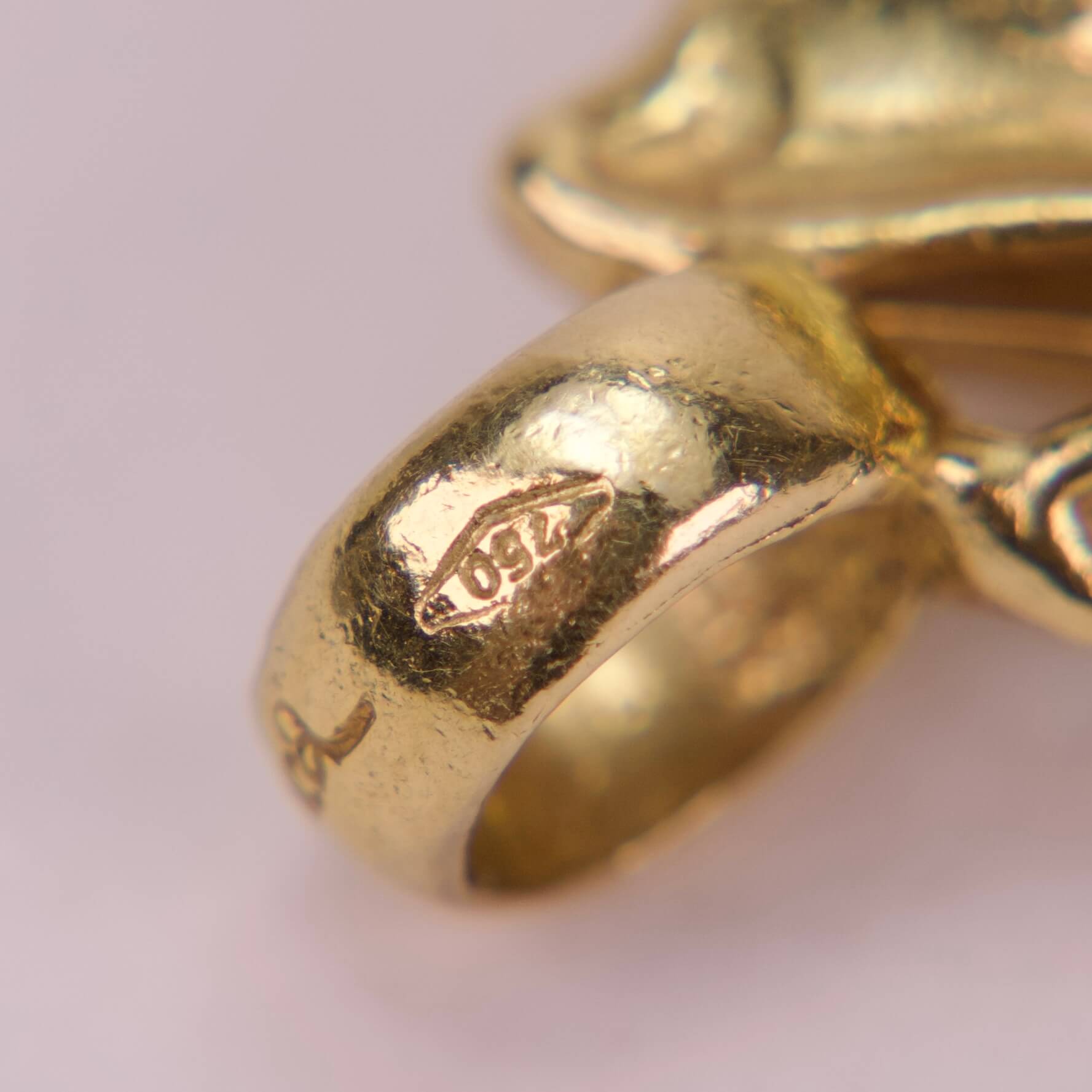 Gold ring with engraved hallmarks close-up.