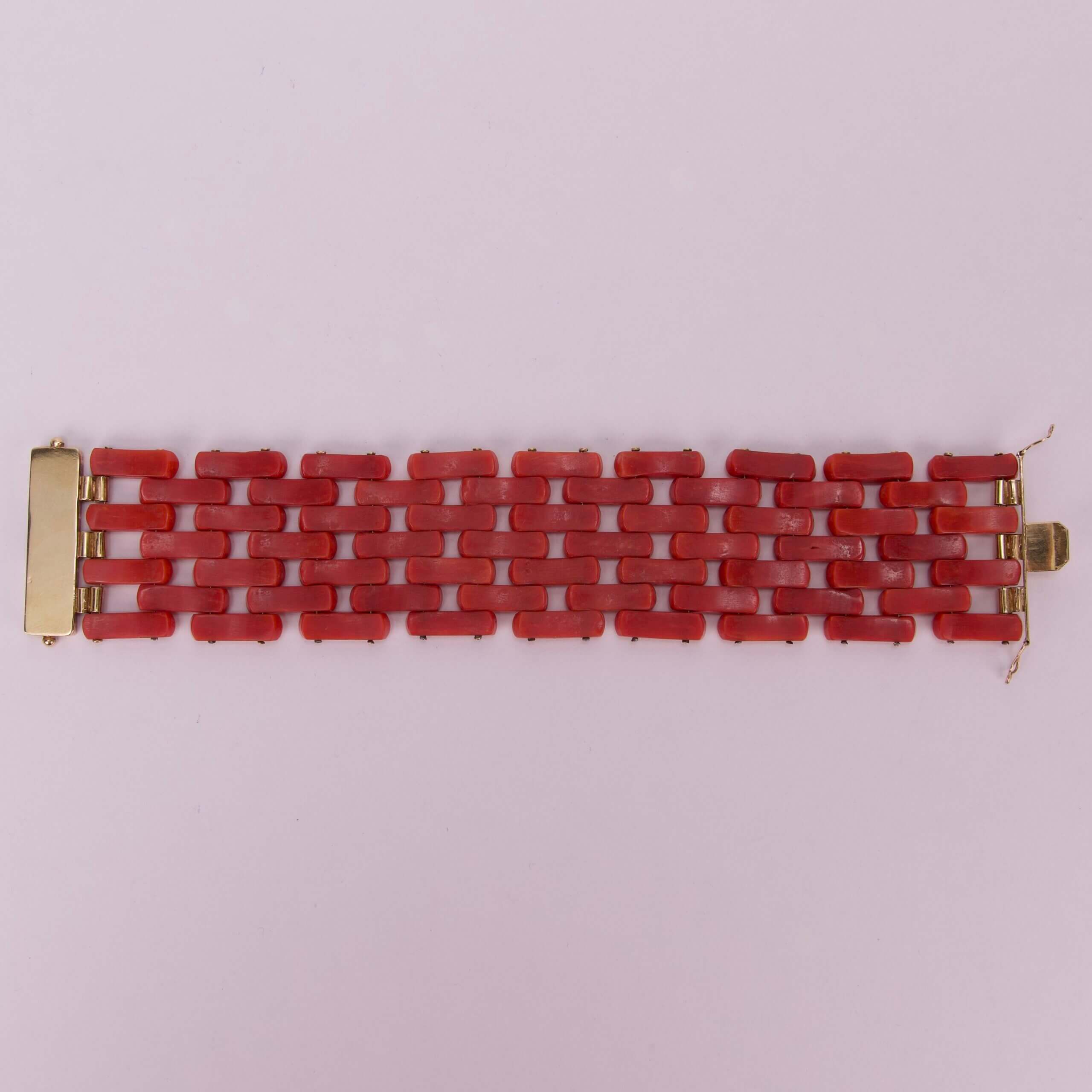 Red link bracelet with gold clasps.