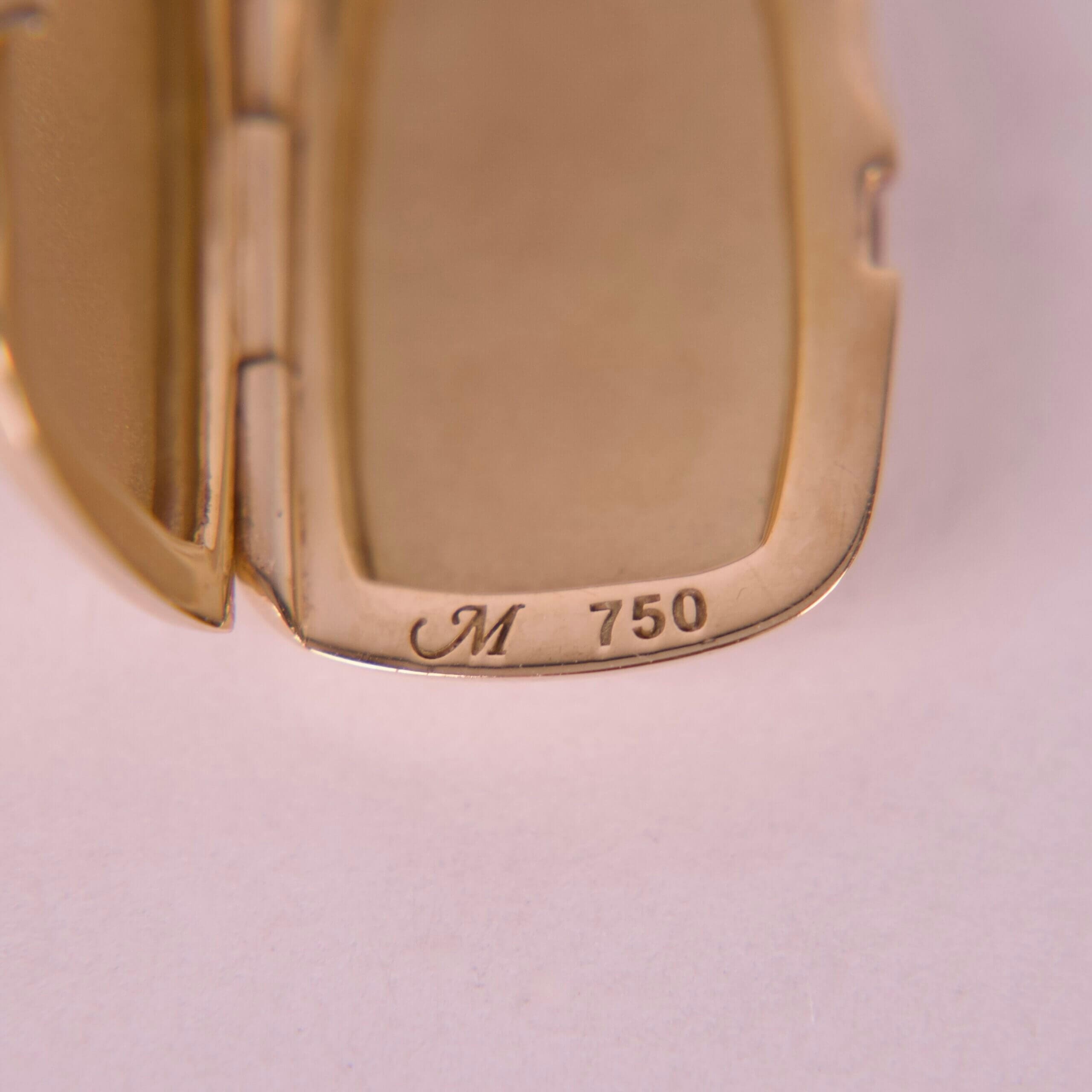 Gold jewelry with "M 750" engraving detail.