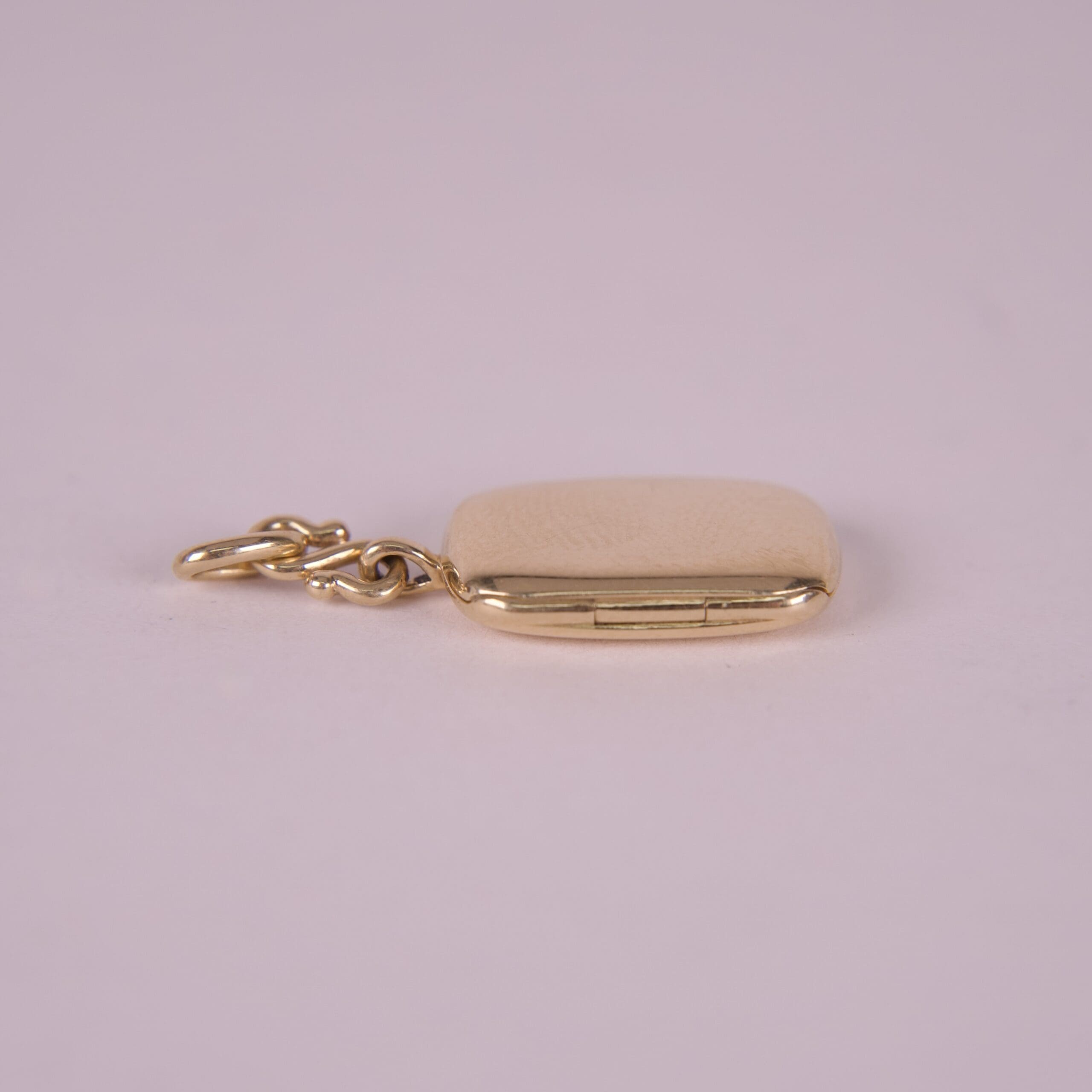 Gold locket with a small chain attached.