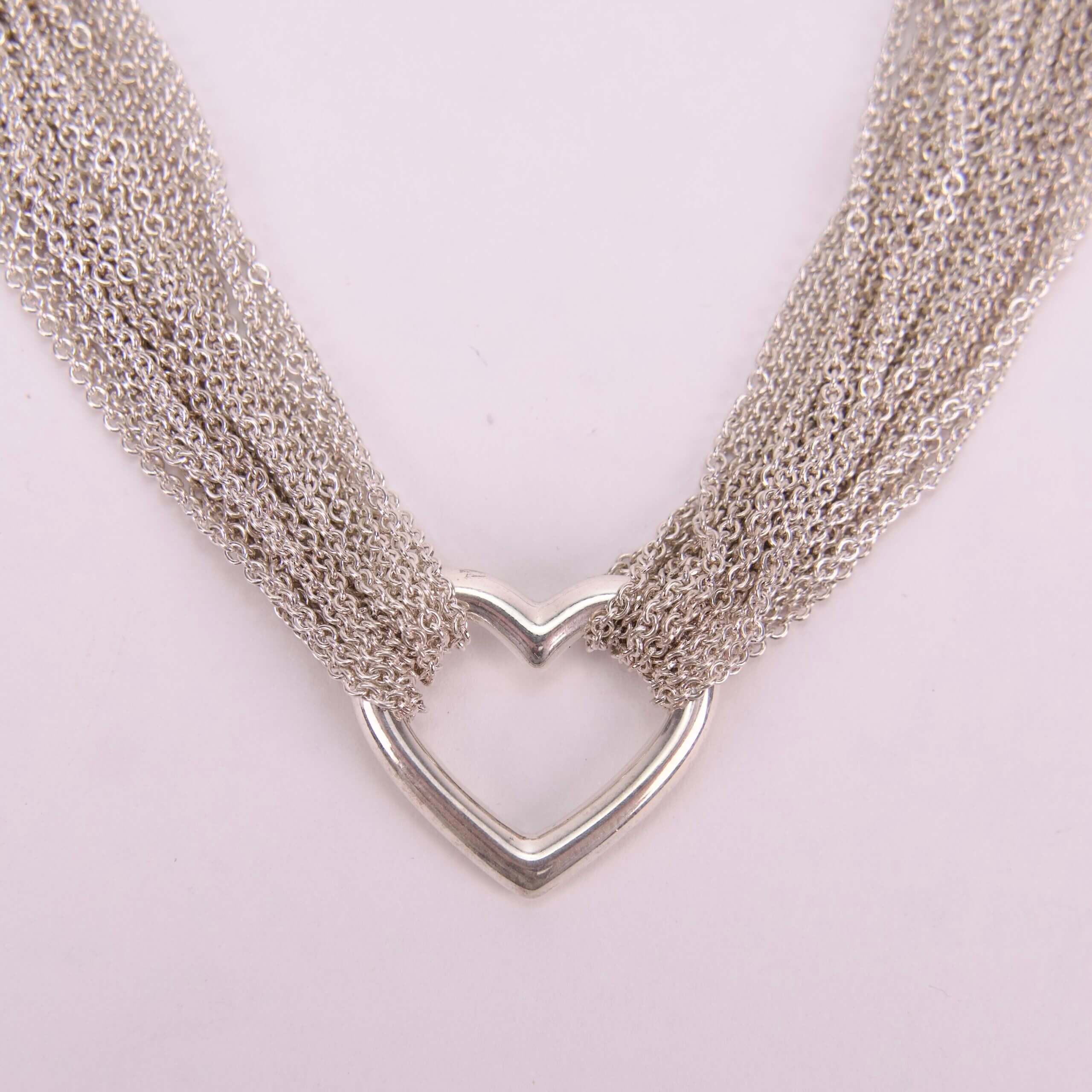 Silver heart necklace with multiple chains.
