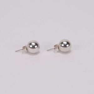 Silver ball stud earrings on white background.