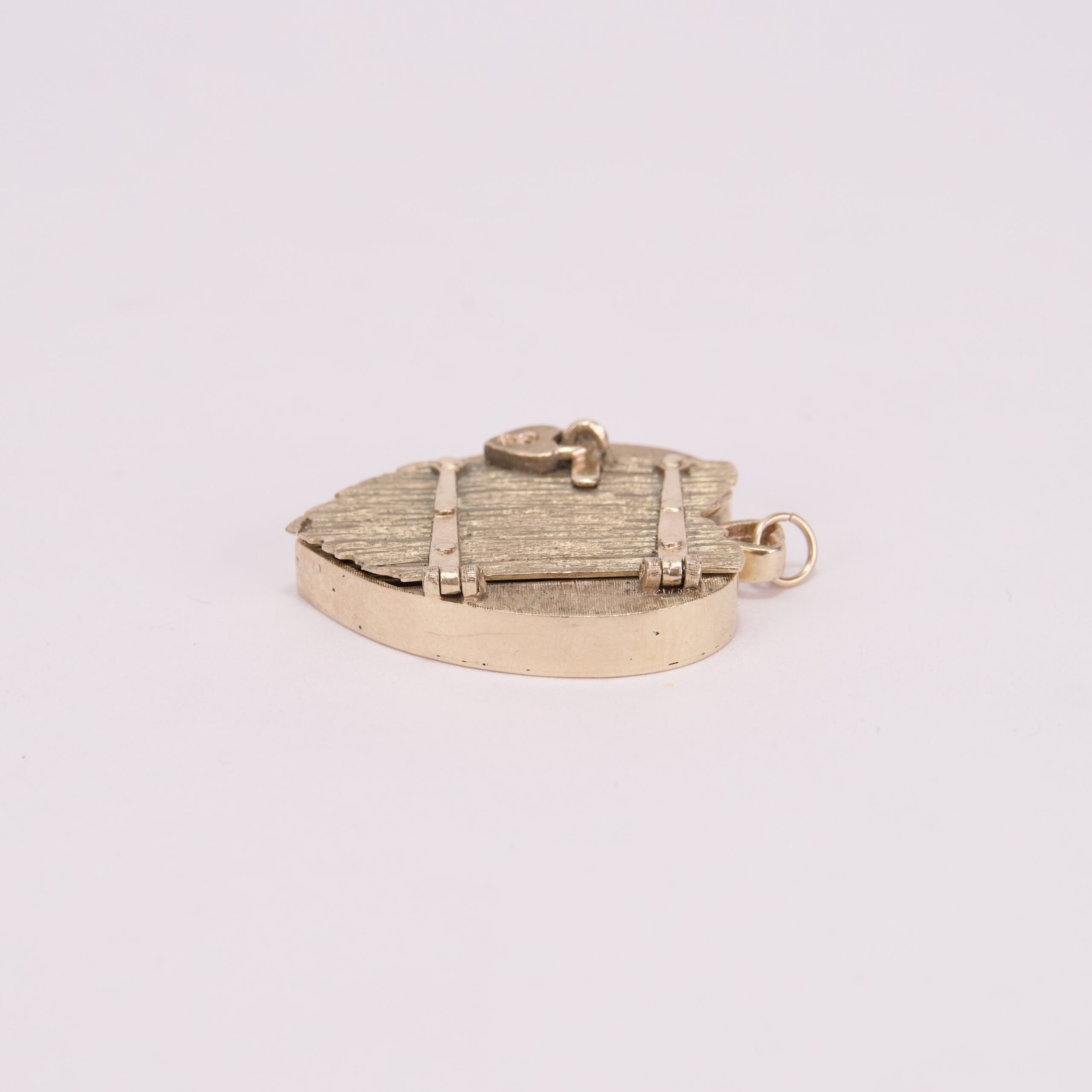 Gold shield-shaped pendant on white background.