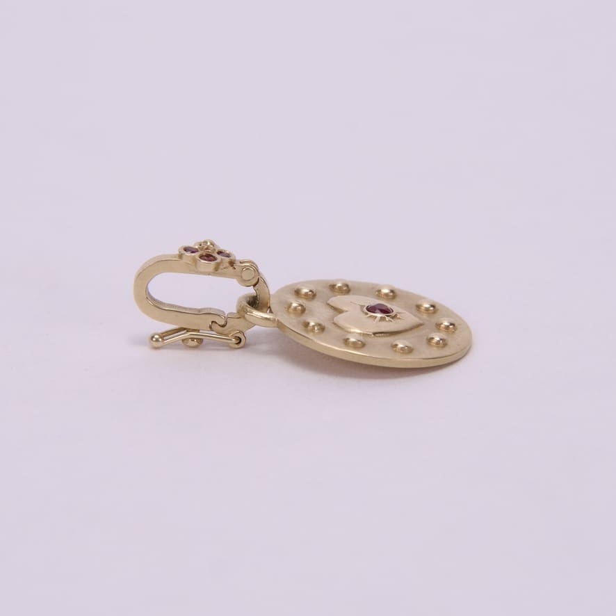 Gold earring with pink gemstone details.