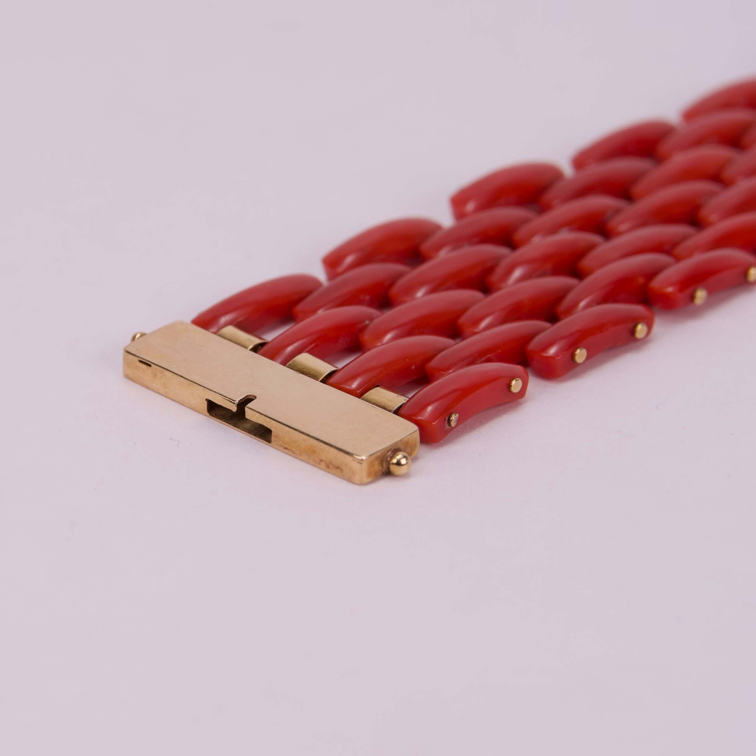 Red bracelet with gold clasp detail.