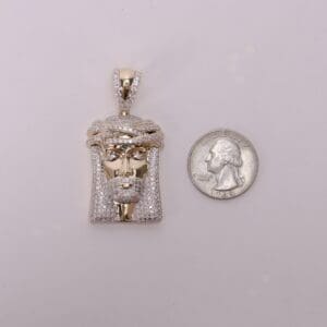 Gold pendant and quarter for size comparison.