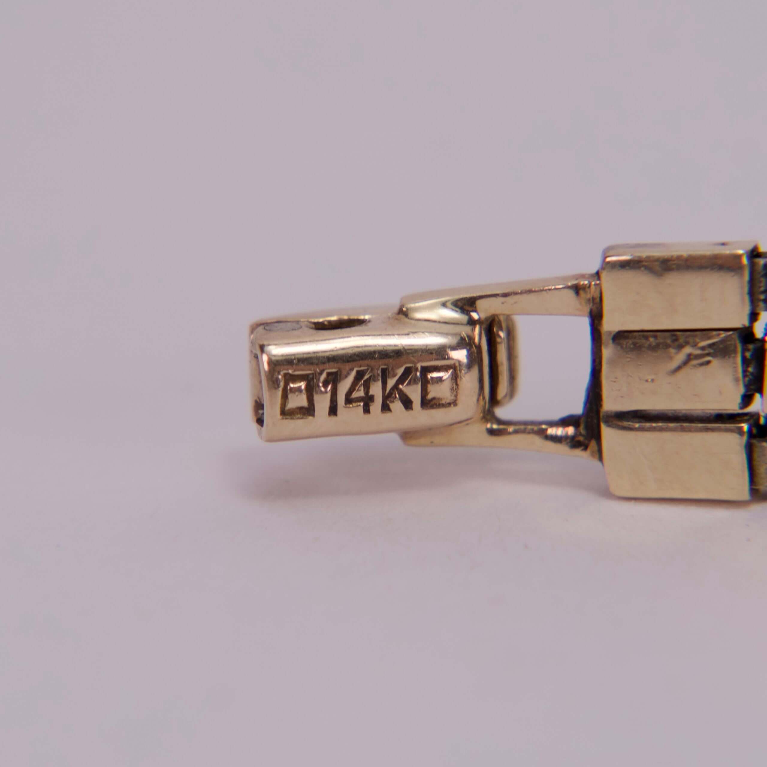 Gold clasp with "914KC" engraving detail.