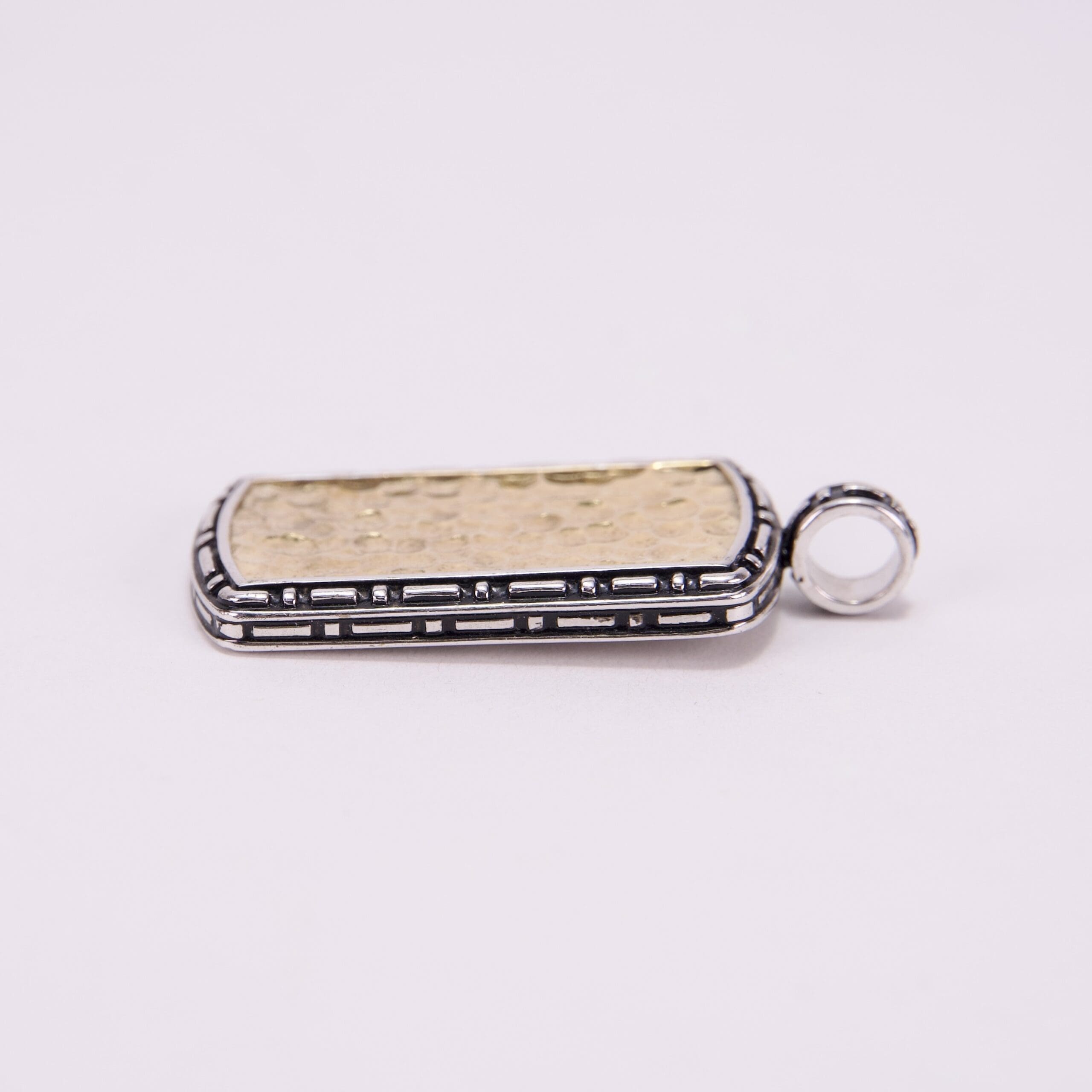 Gold and silver rectangular pendant with loop.