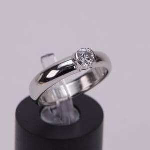 Silver ring with a round diamond setting.
