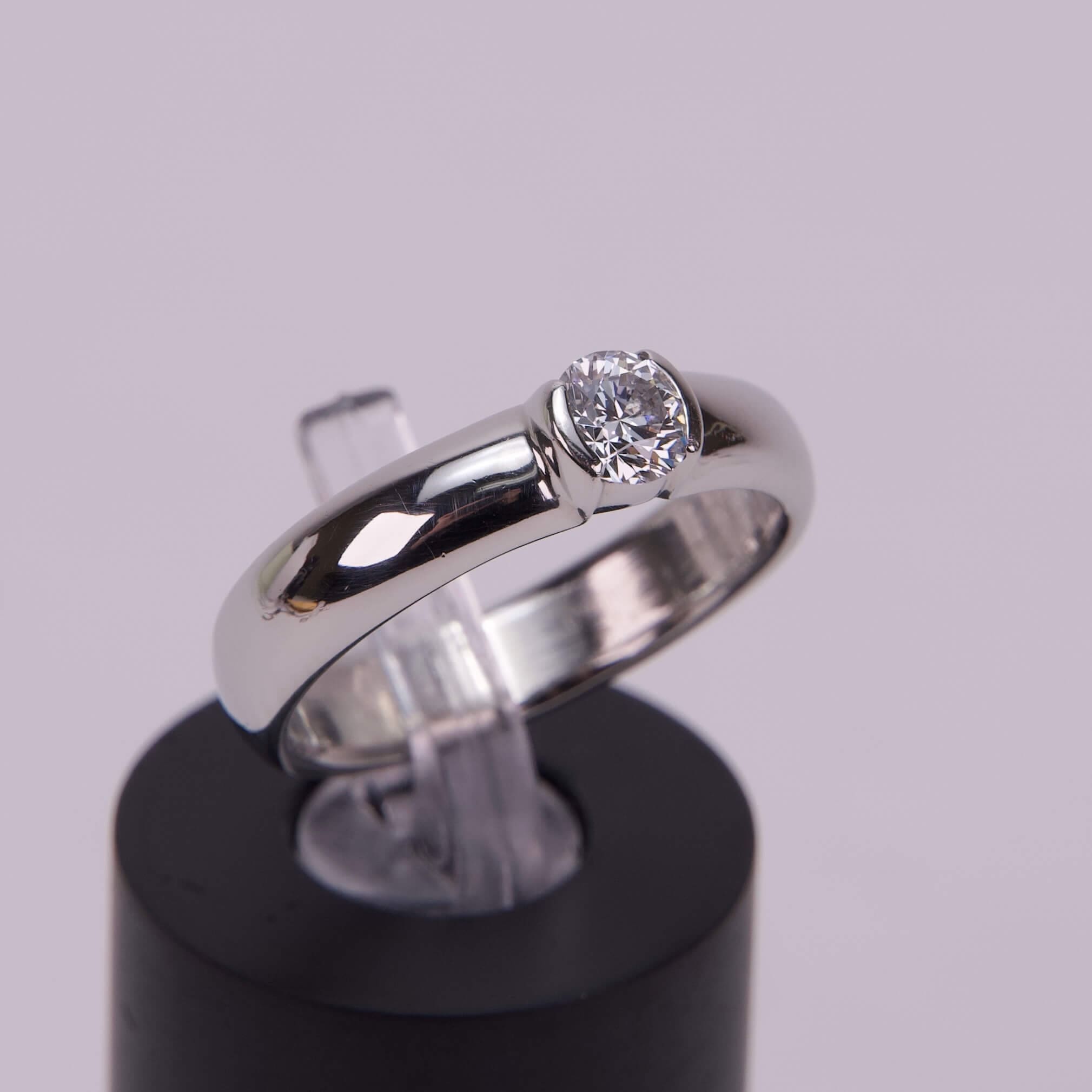 Silver ring with a round diamond setting.