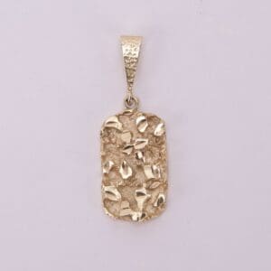 Gold textured pendant on plain background.