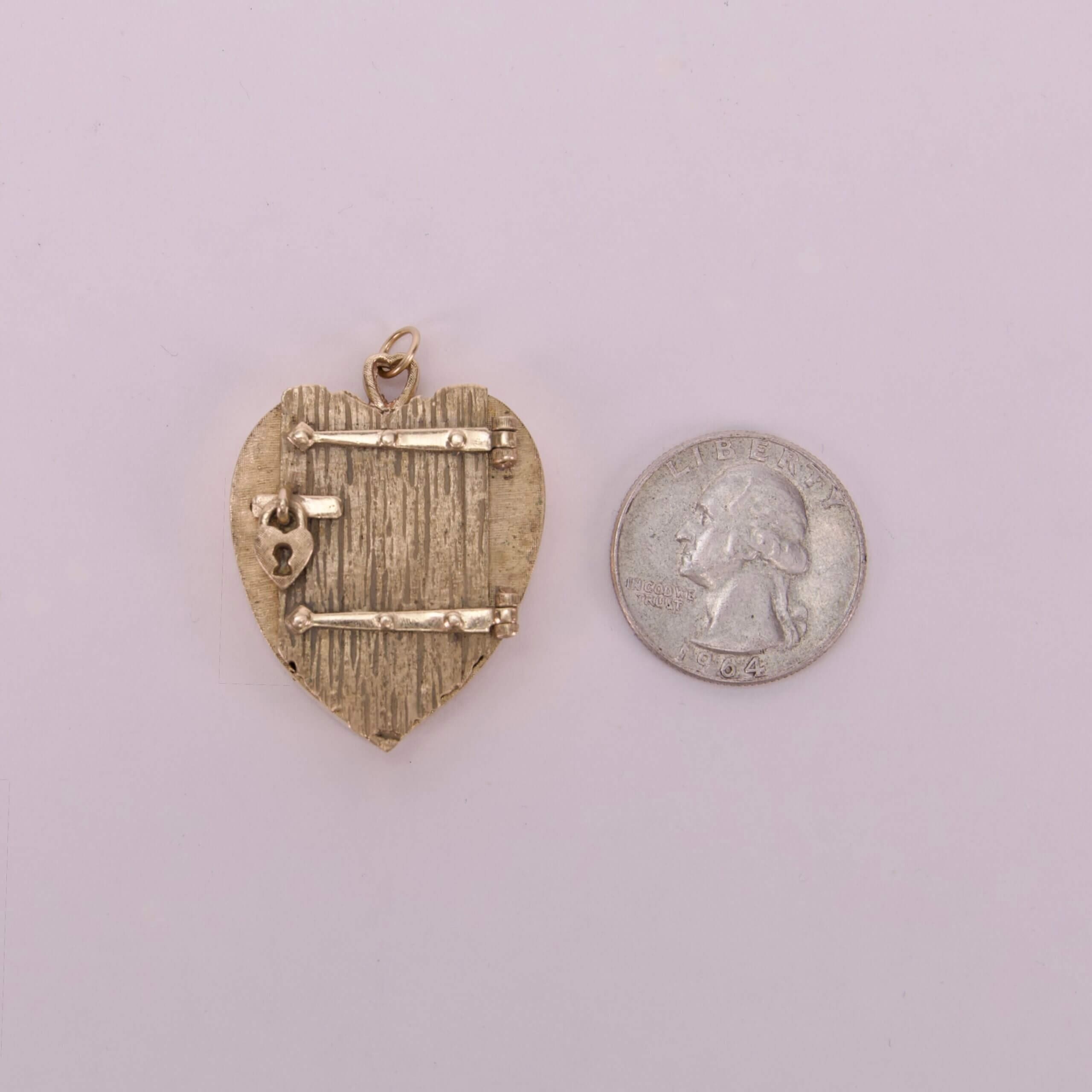 Heart-shaped pendant beside a quarter coin.