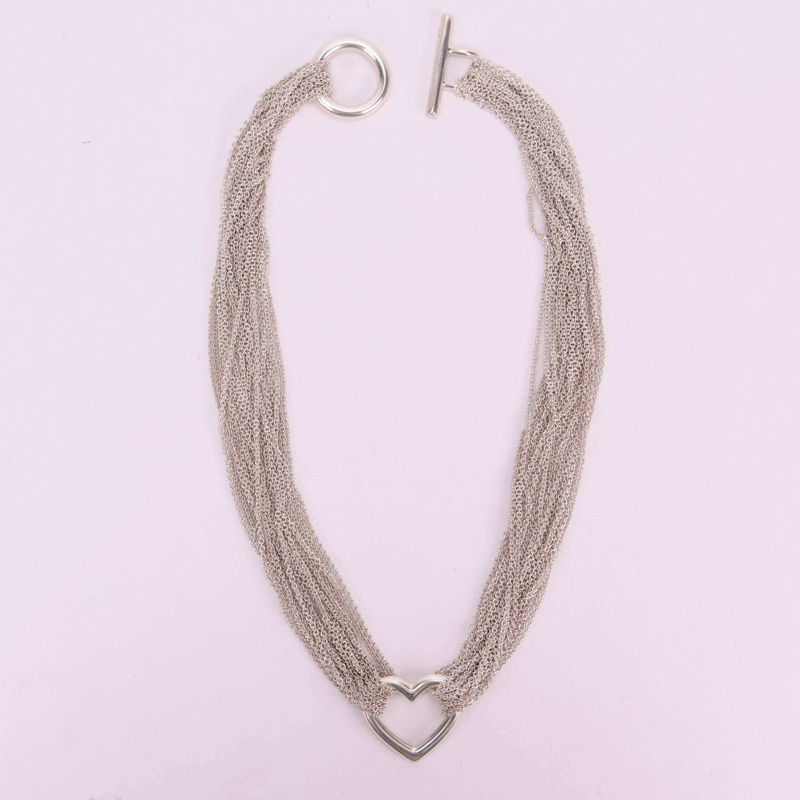 Silver necklace with heart-shaped pendant.
