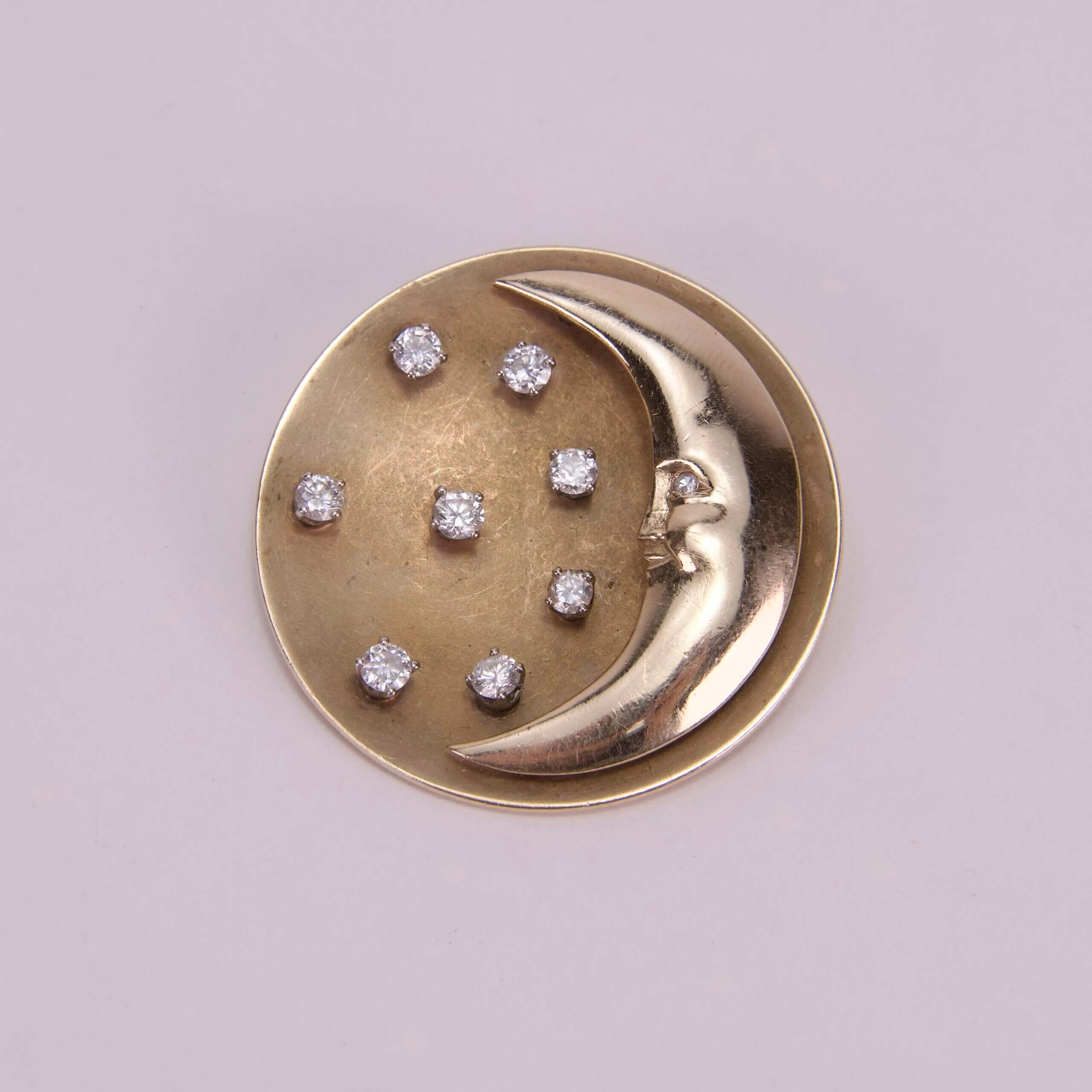 Gold moon brooch with diamond stars.