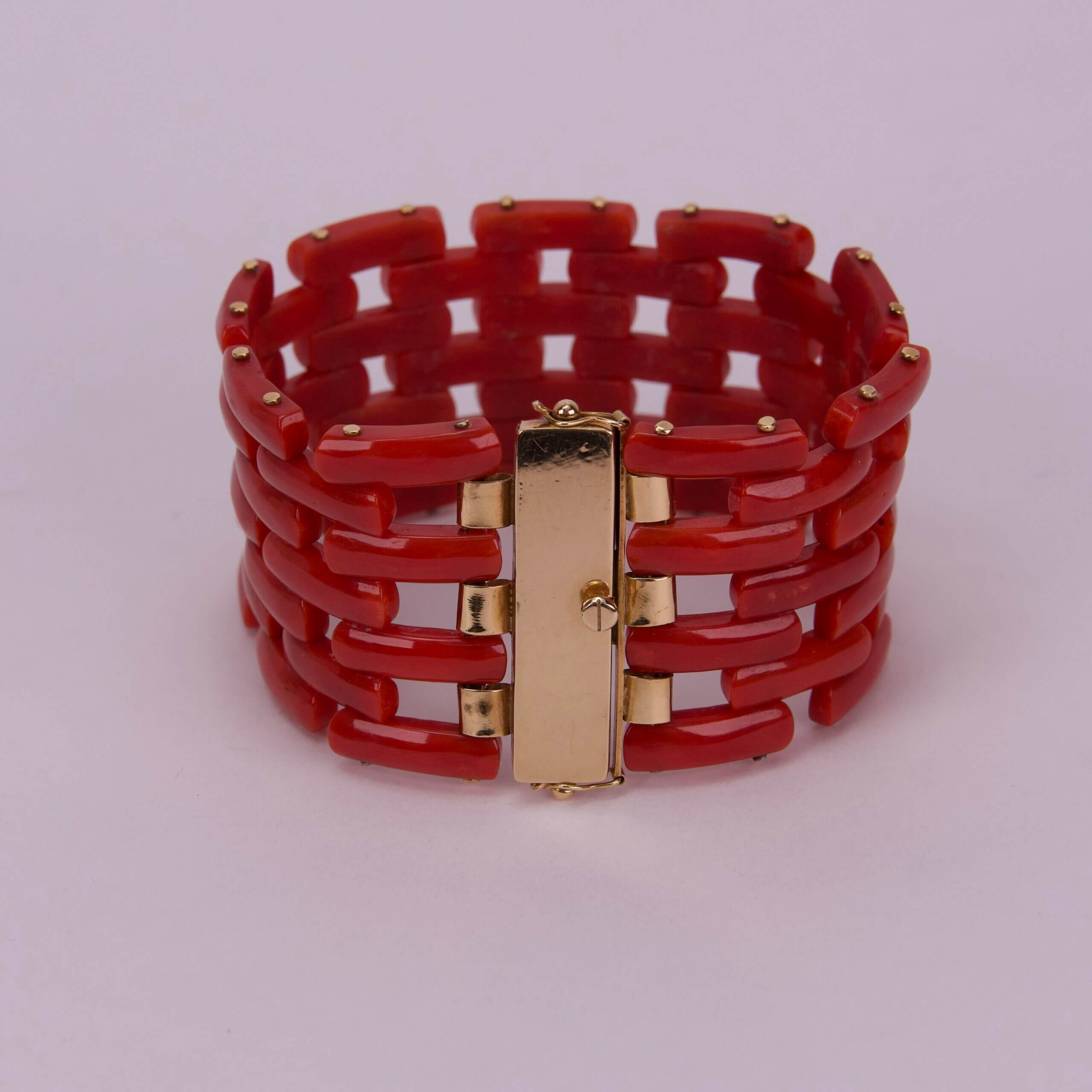 Red bracelet with gold clasp details.