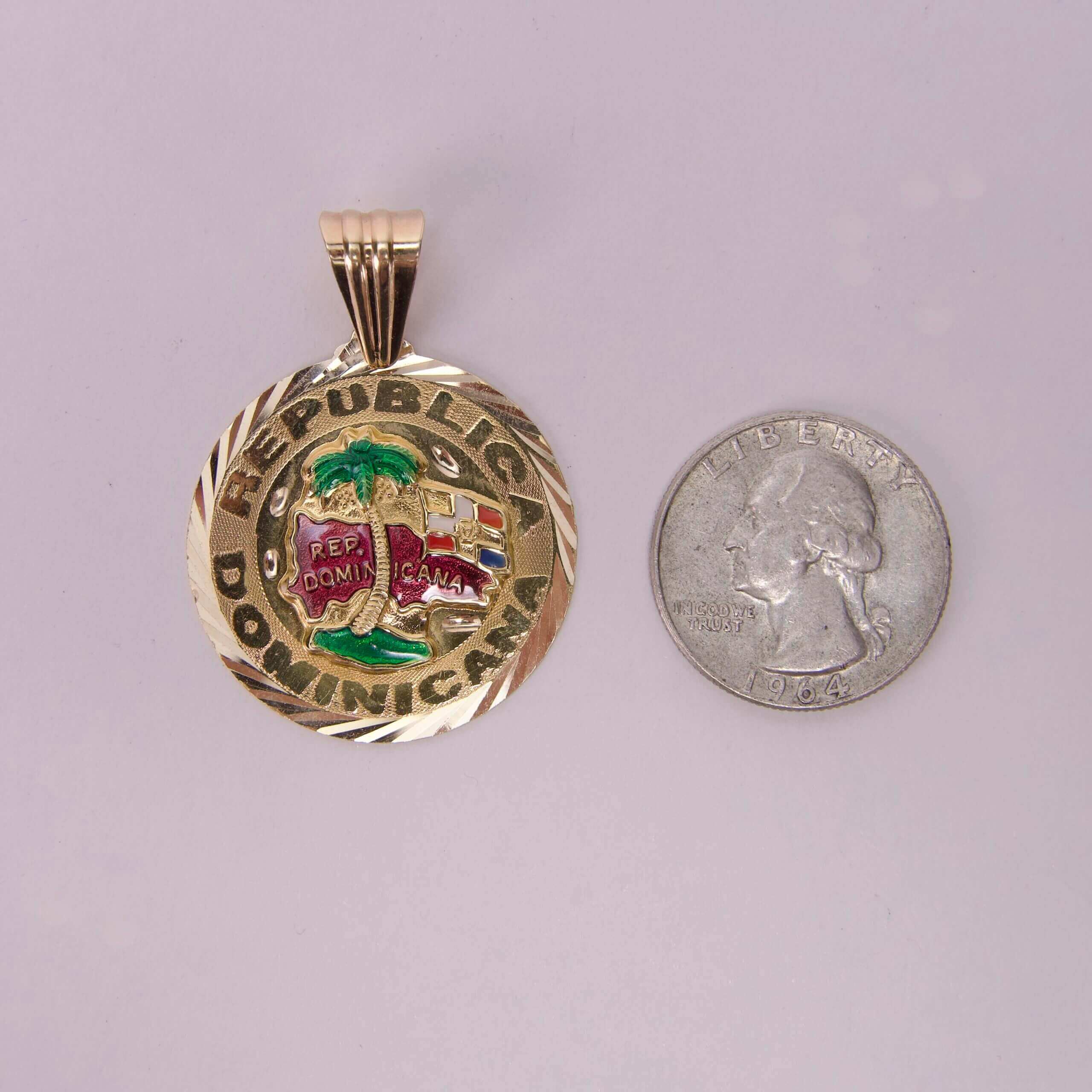 Gold Dominican Republic pendant beside quarter.