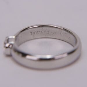 Silver ring with engraved brand name inside.