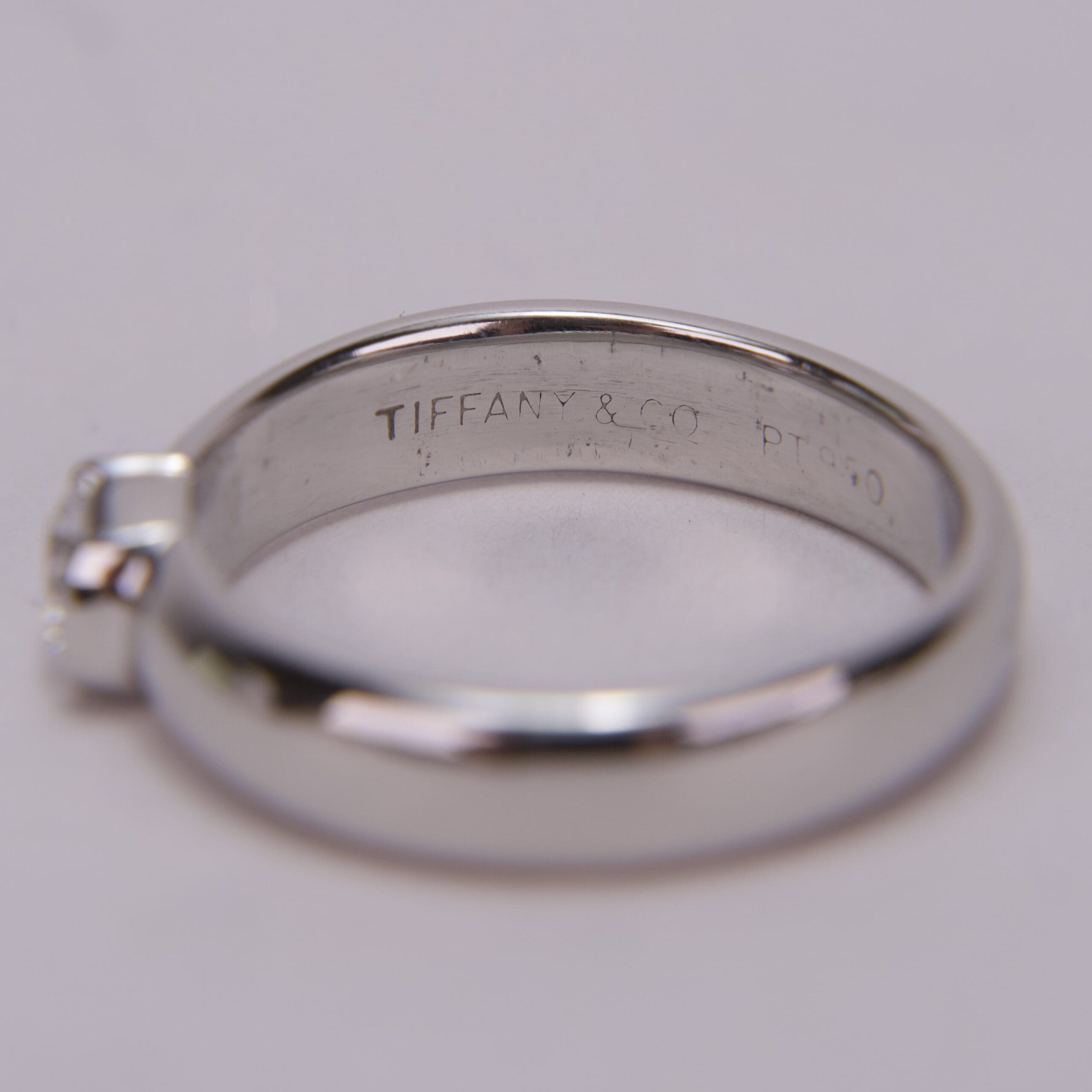 Silver ring with engraved brand name inside.