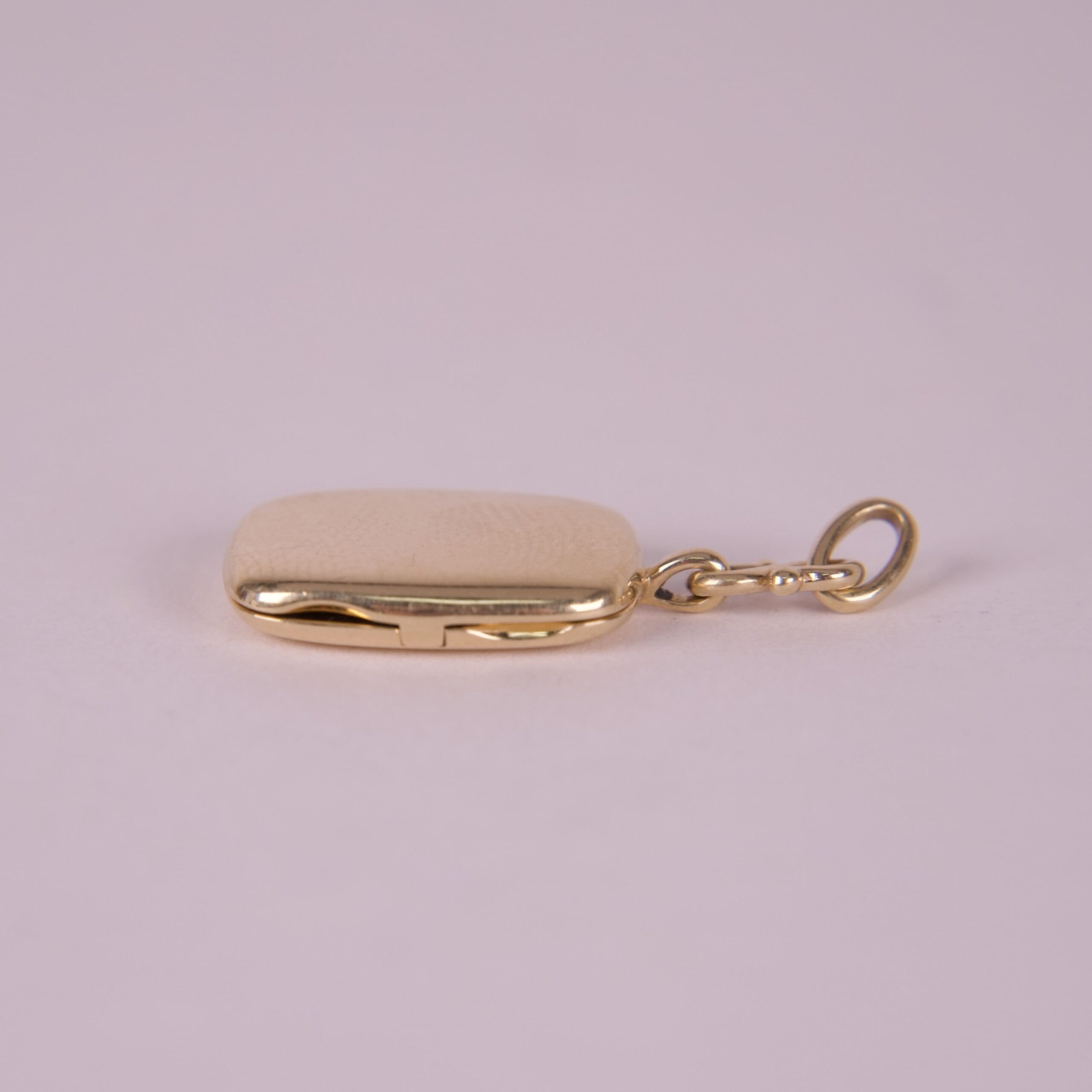 Gold keychain with rectangular pendant.