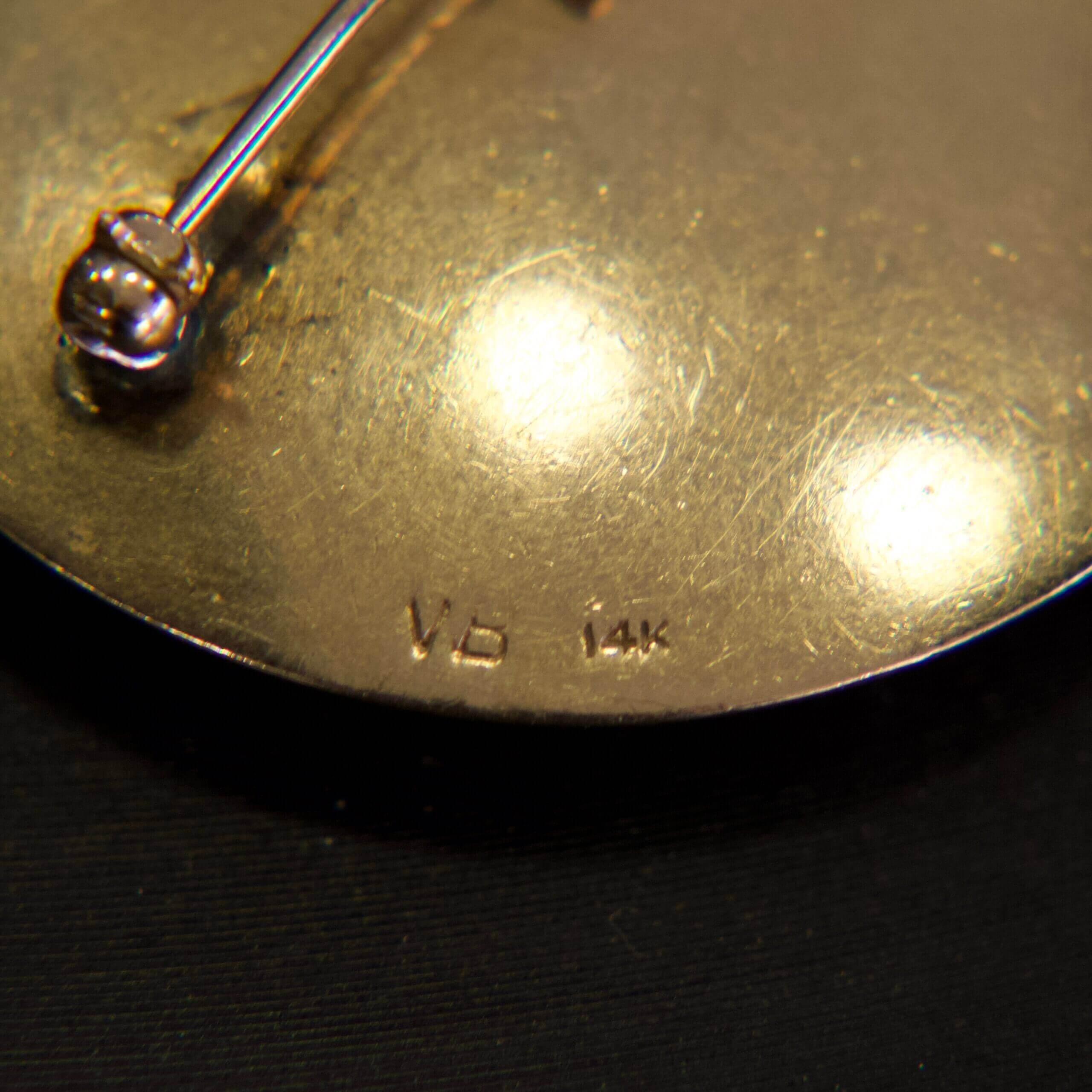 Gold jewelry piece with "14k" marking.