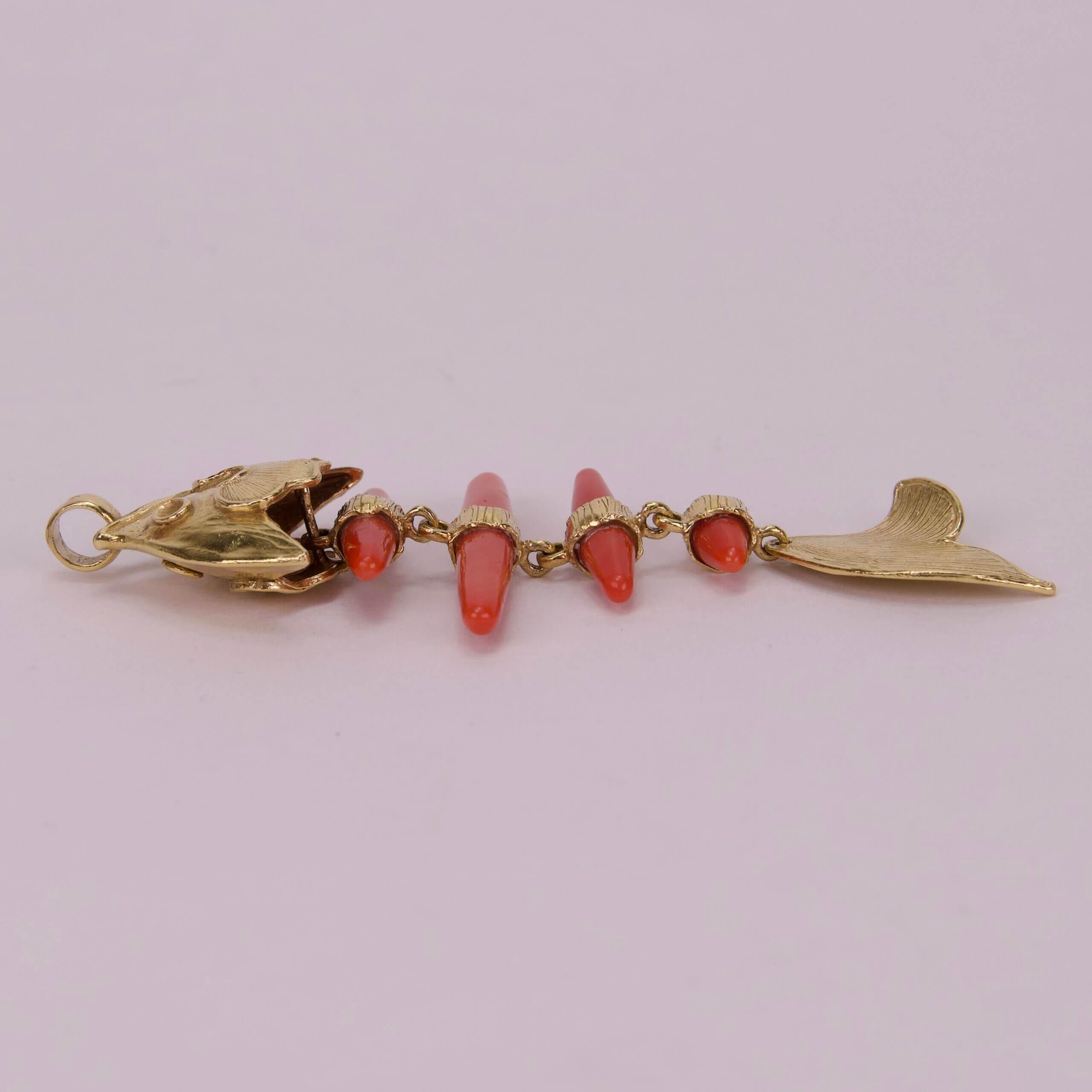 Gold fish skeleton pendant with red stones.
