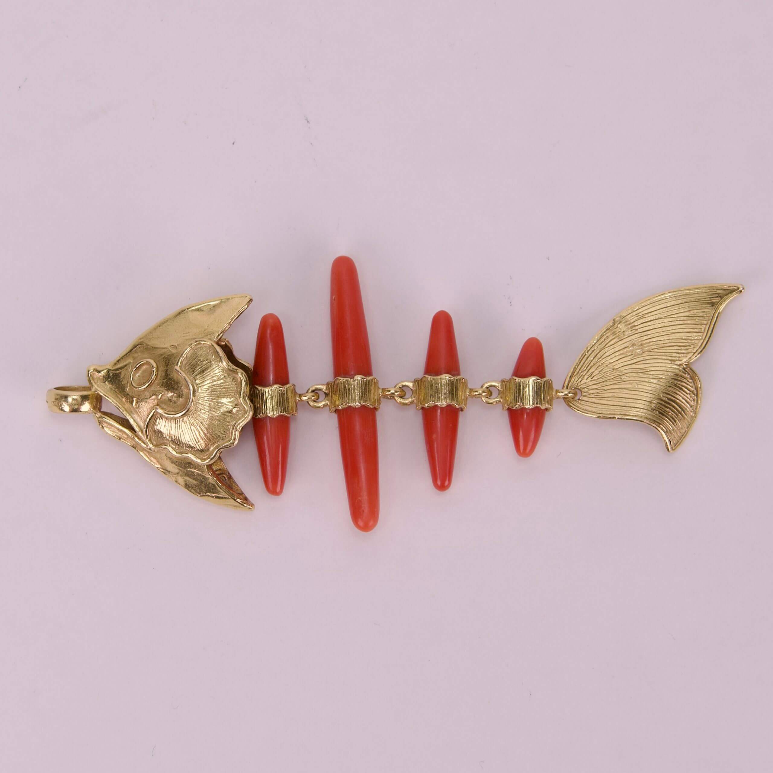 Gold and red fish-shaped jewelry piece.