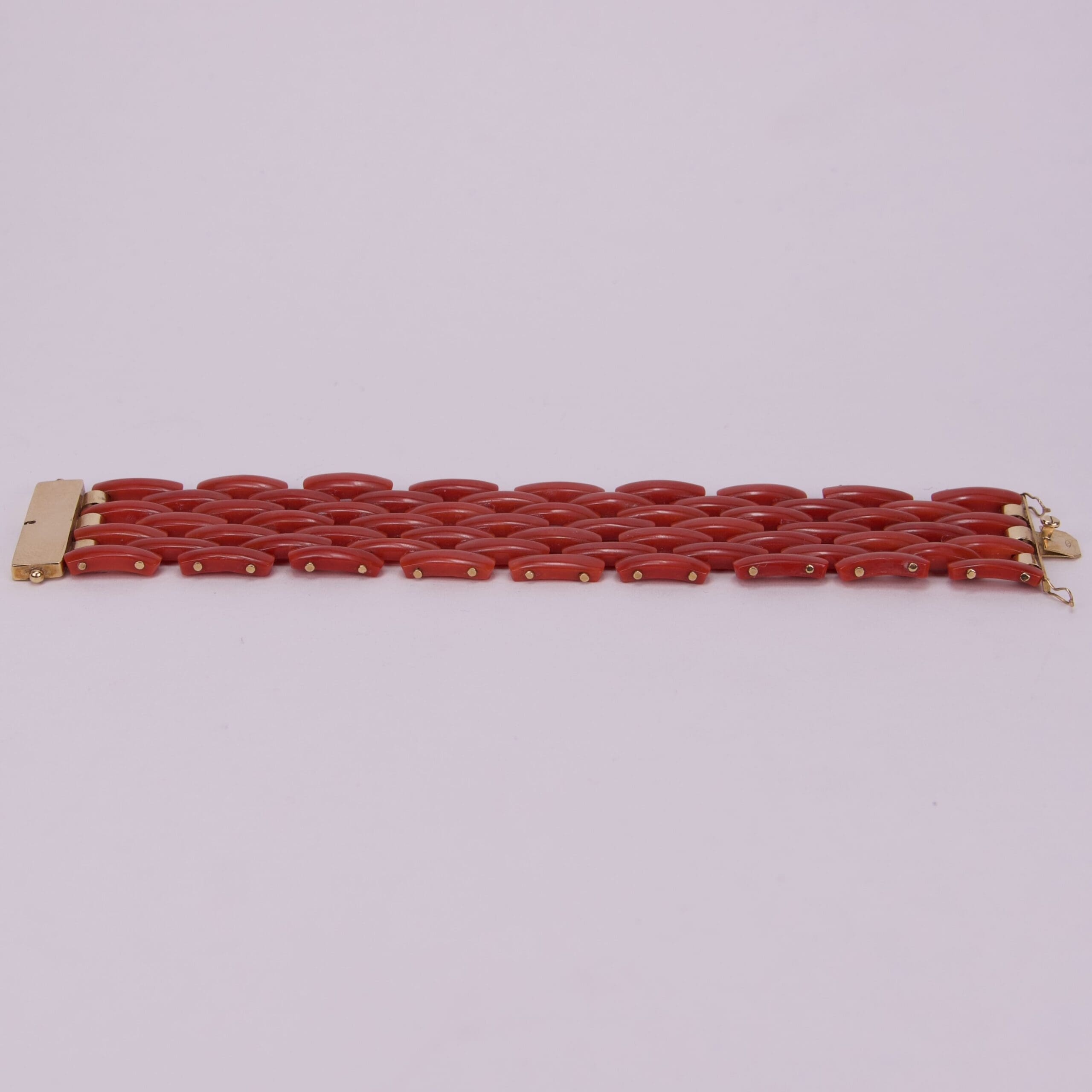 Red link bracelet with gold clasp.