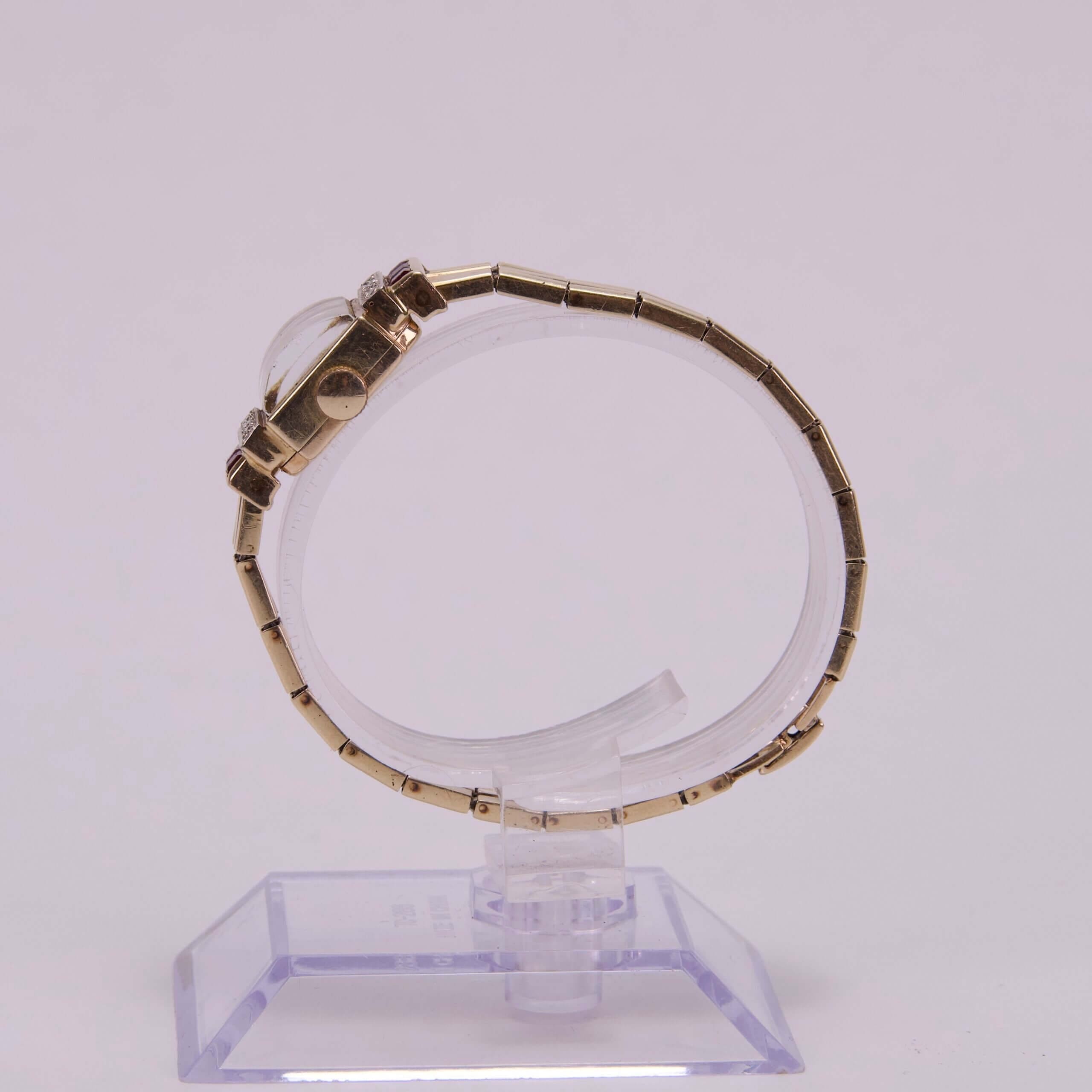 Gold watch on a transparent display stand.