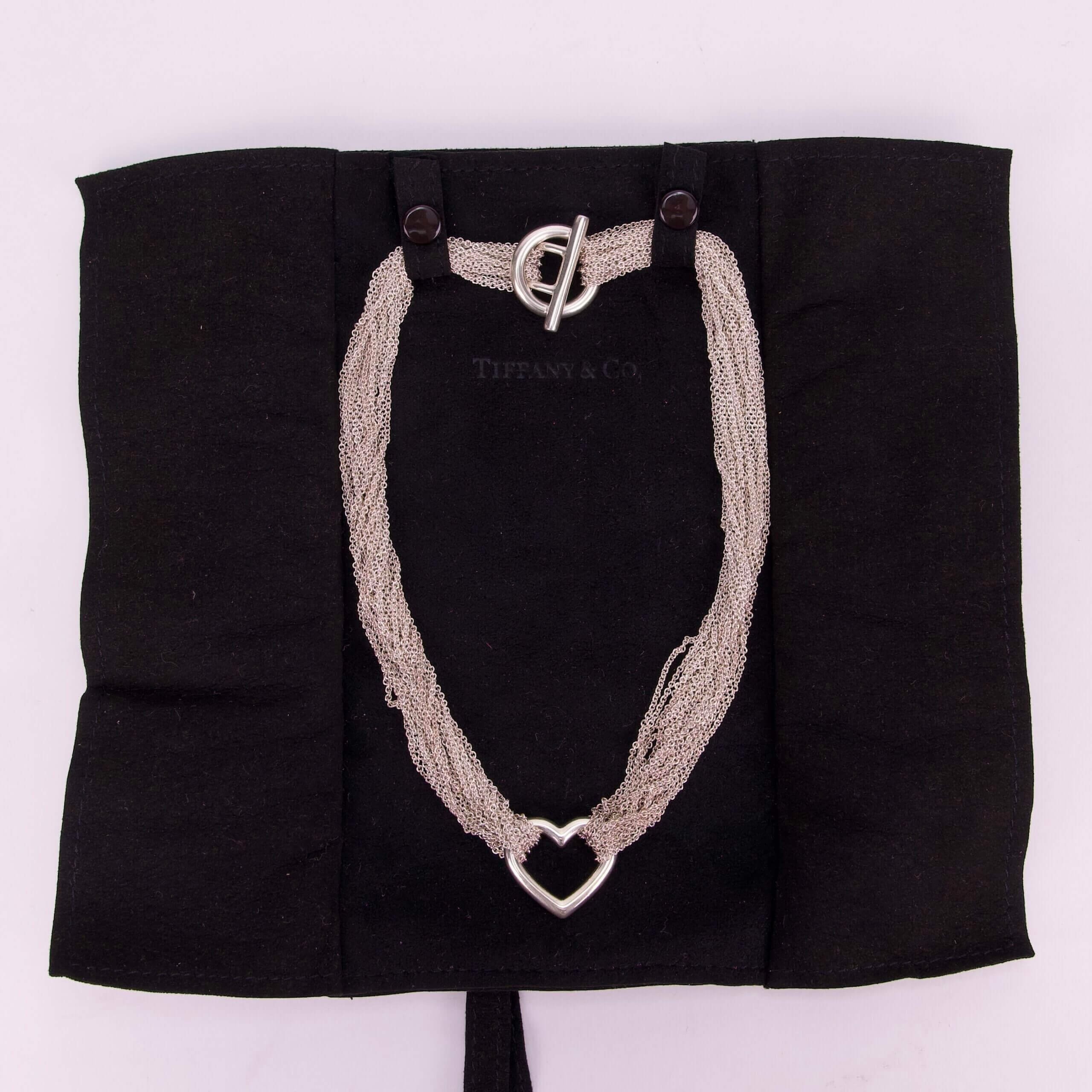Heart-shaped necklace on black fabric display.
