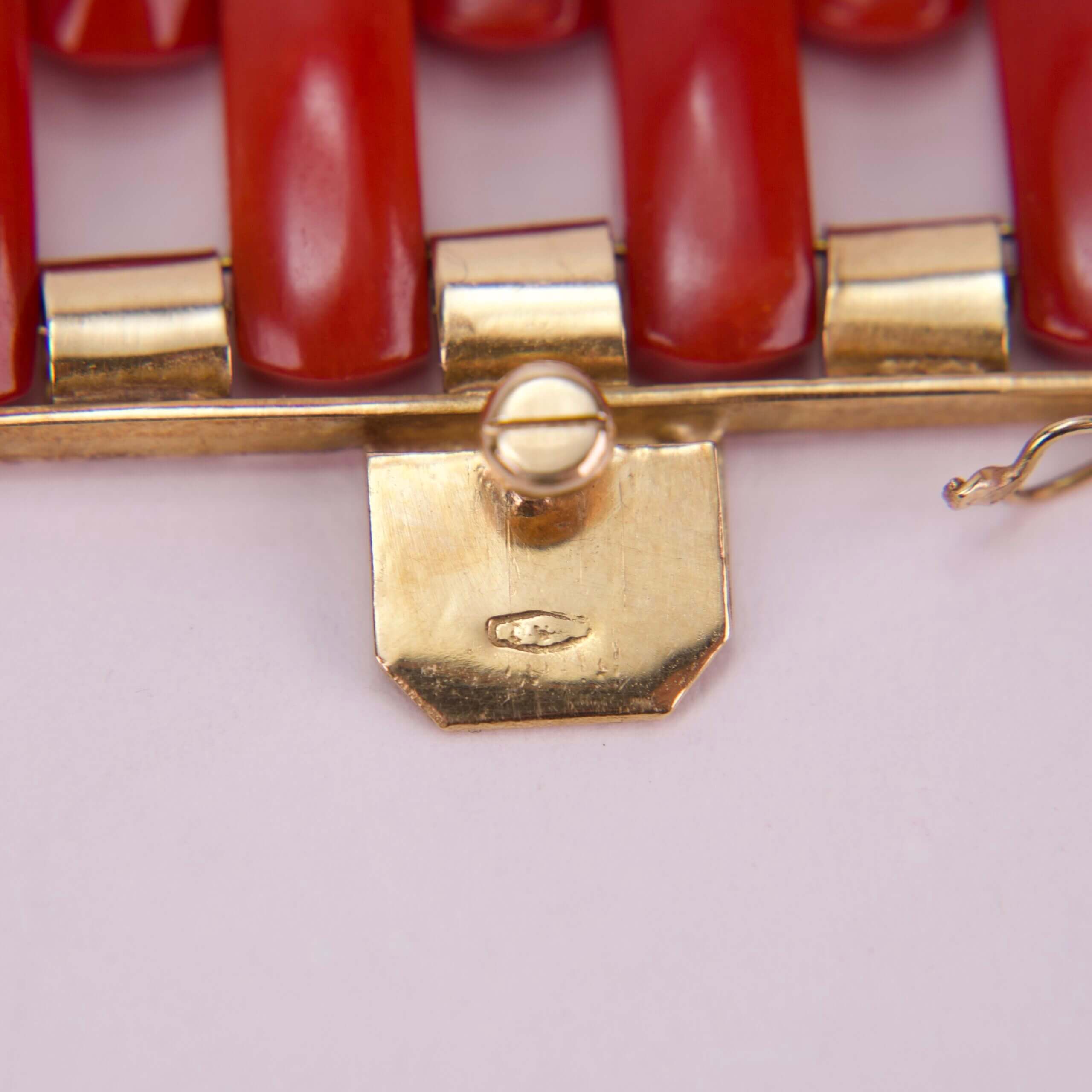 Gold clasp with red beads detail.