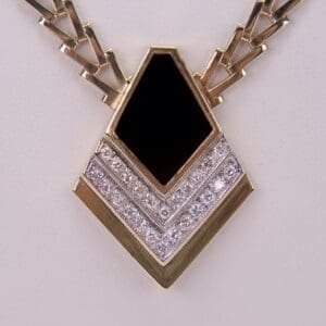 Gold and diamond pendant with black center.