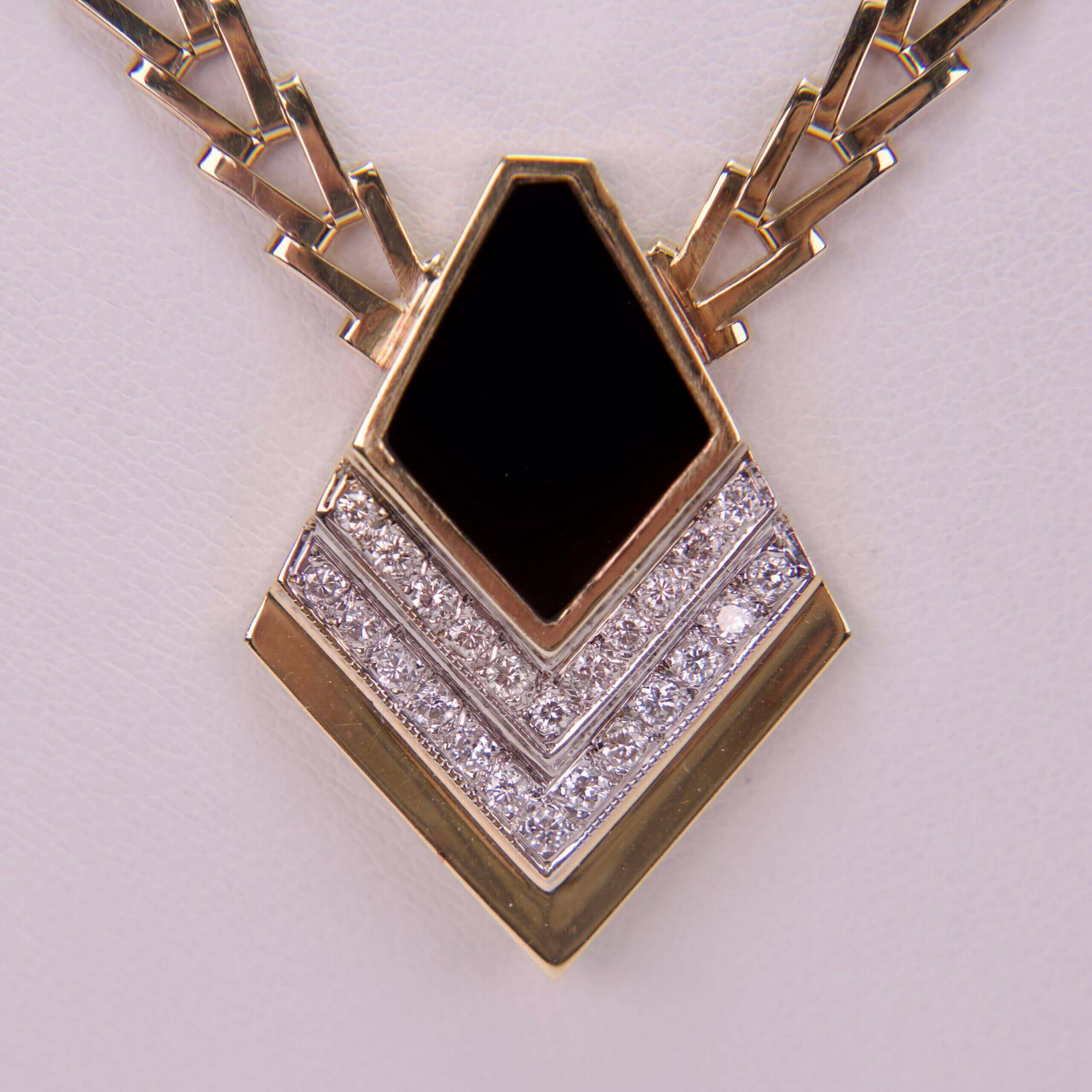 Gold and diamond pendant with black center.
