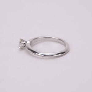 Silver ring with single diamond on band.
