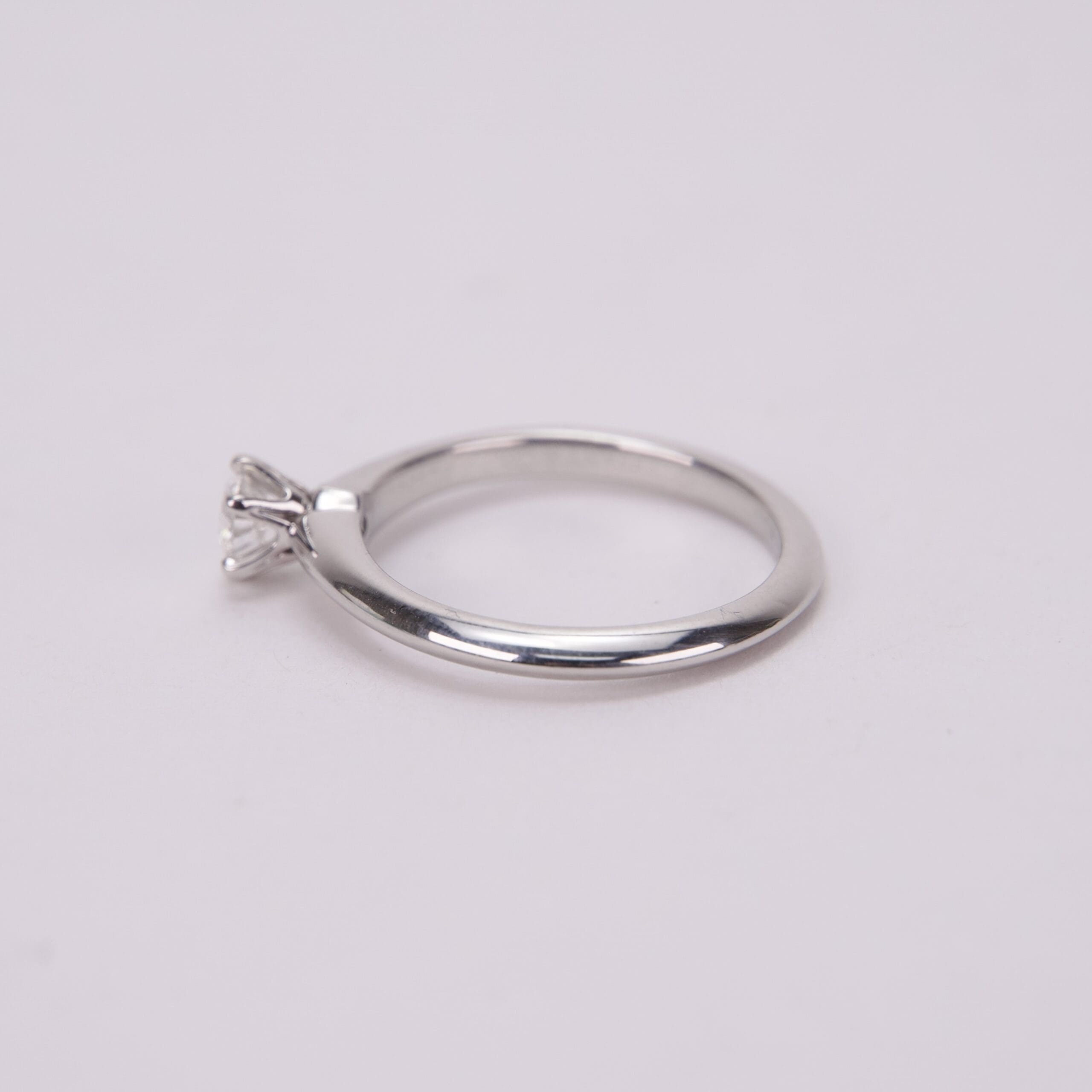 Silver ring with single diamond on band.