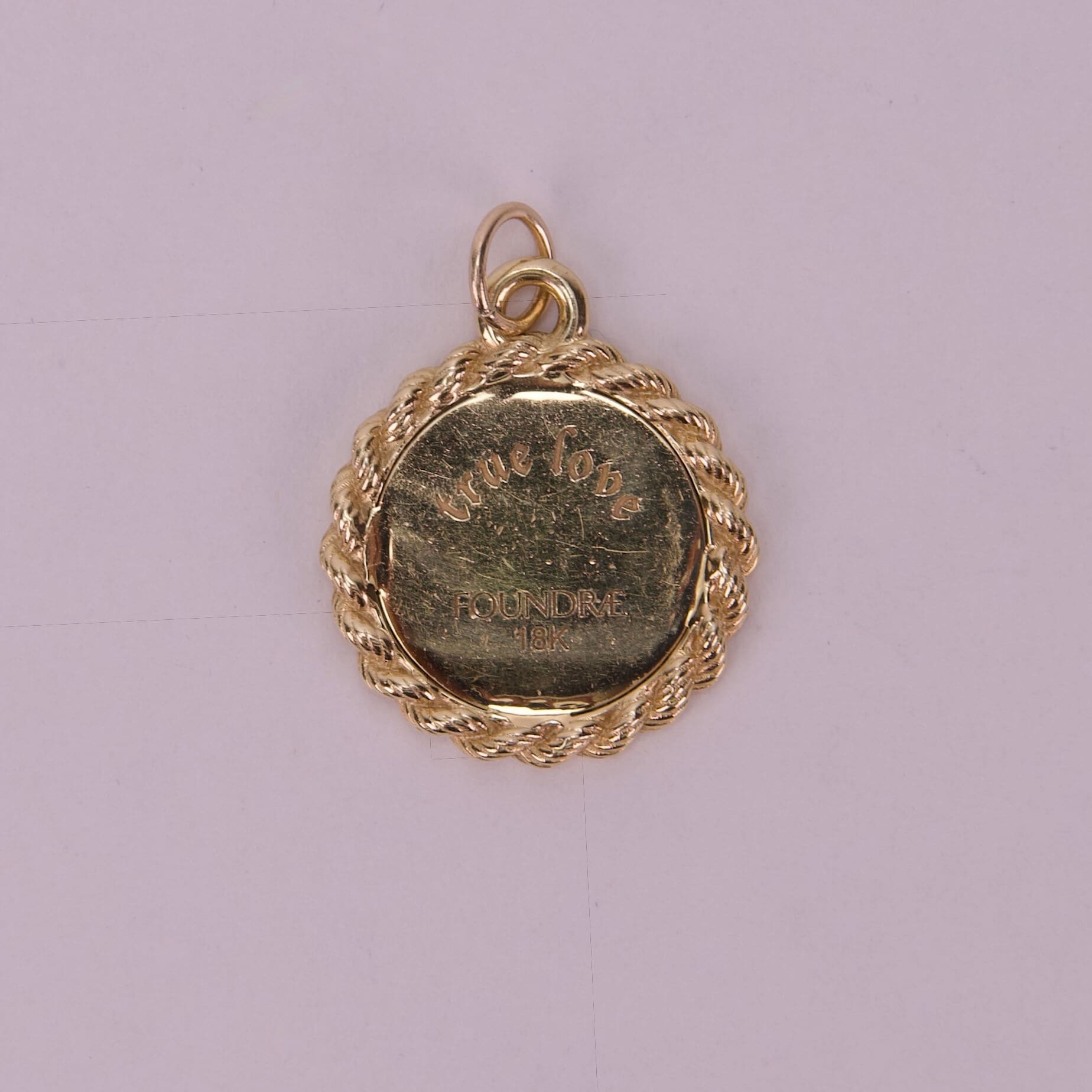 Gold medallion with engraved text.