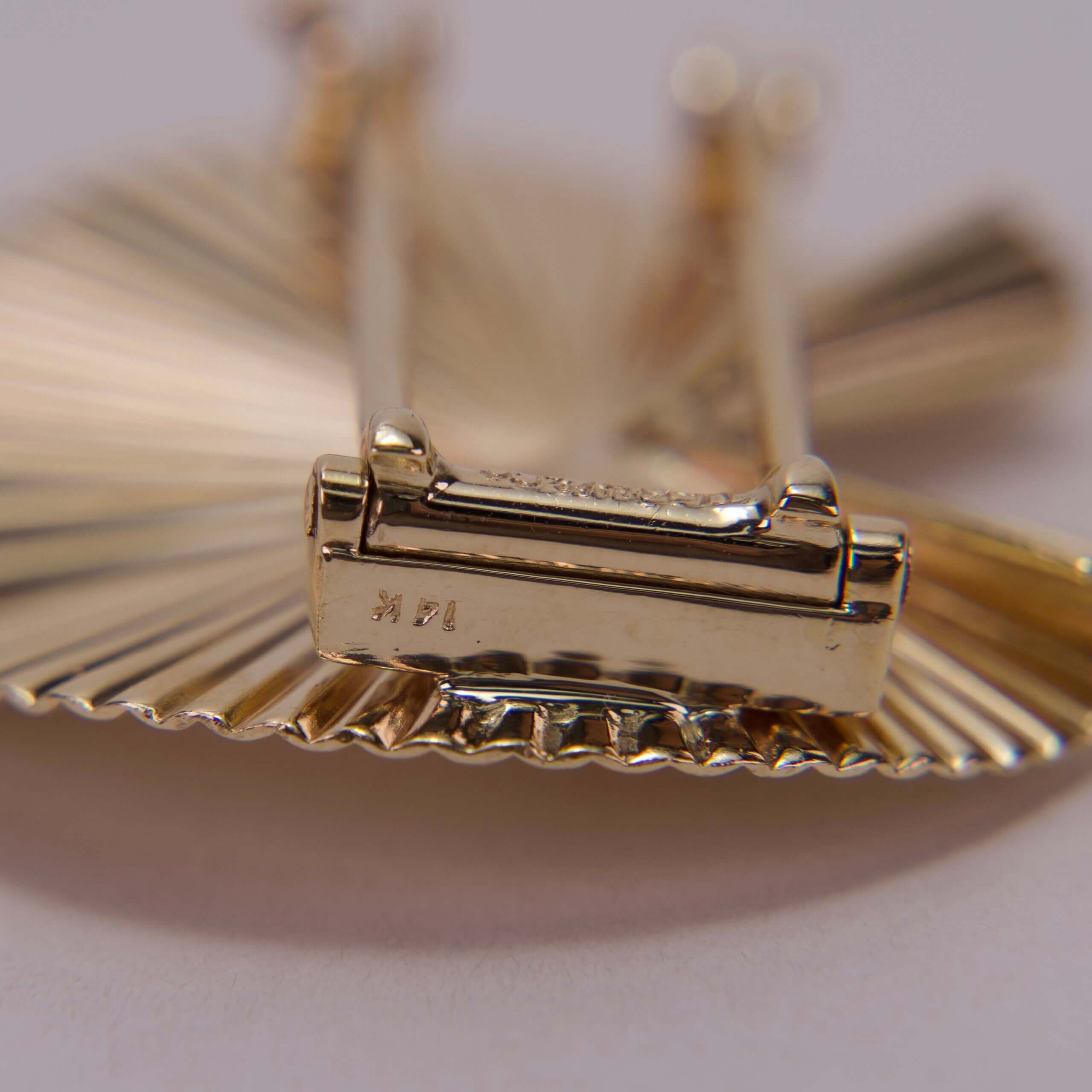 Gold barrette with intricate fan design.