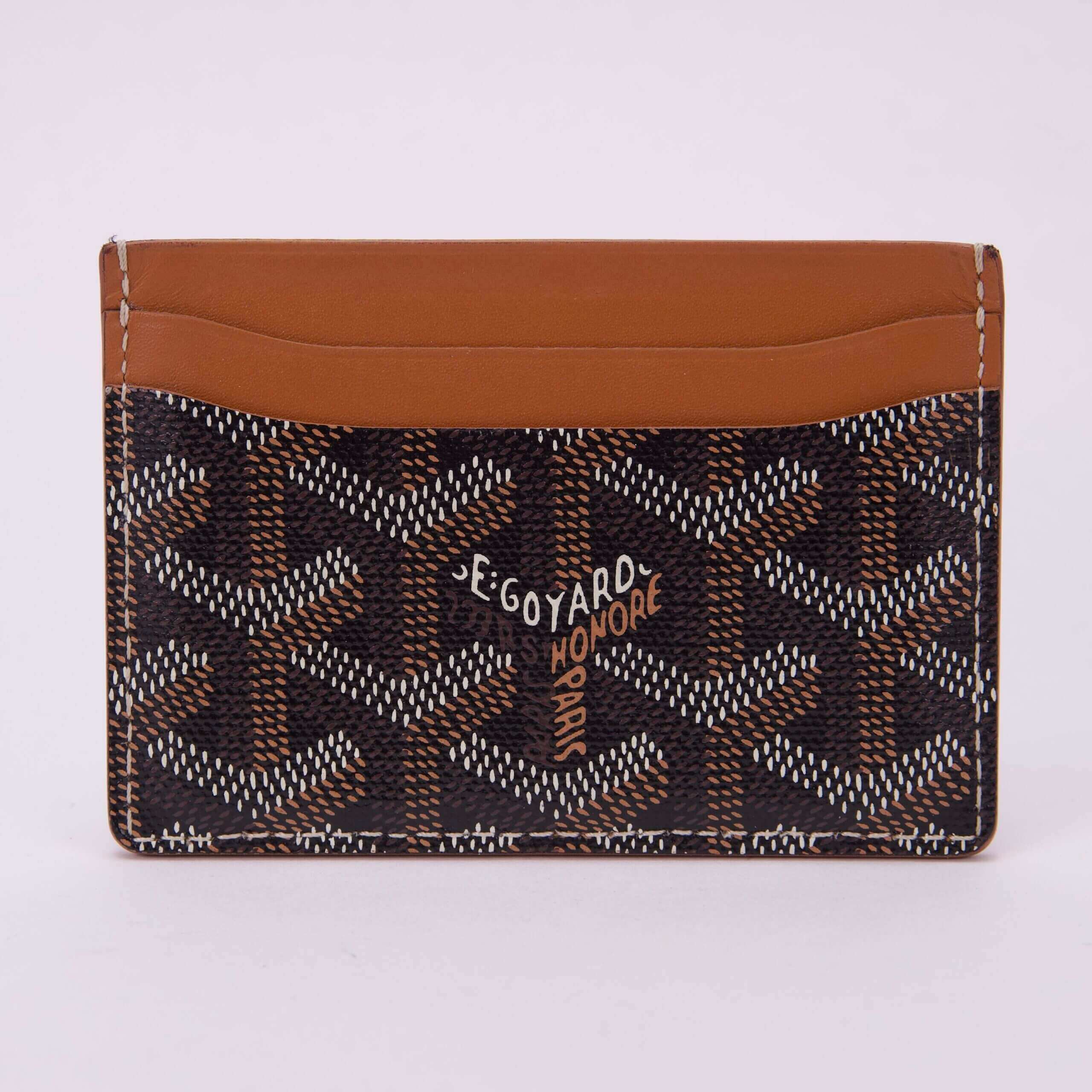 Patterned card holder with brown leather trim.