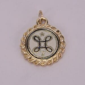Gold pendant with star and decorative symbol.
