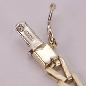 Gold jewelry clasp with intricate detailing.