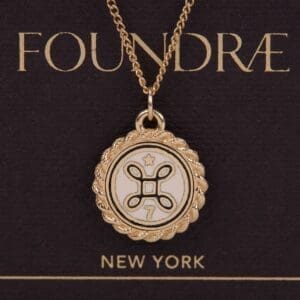 Gold pendant necklace with decorative emblem.